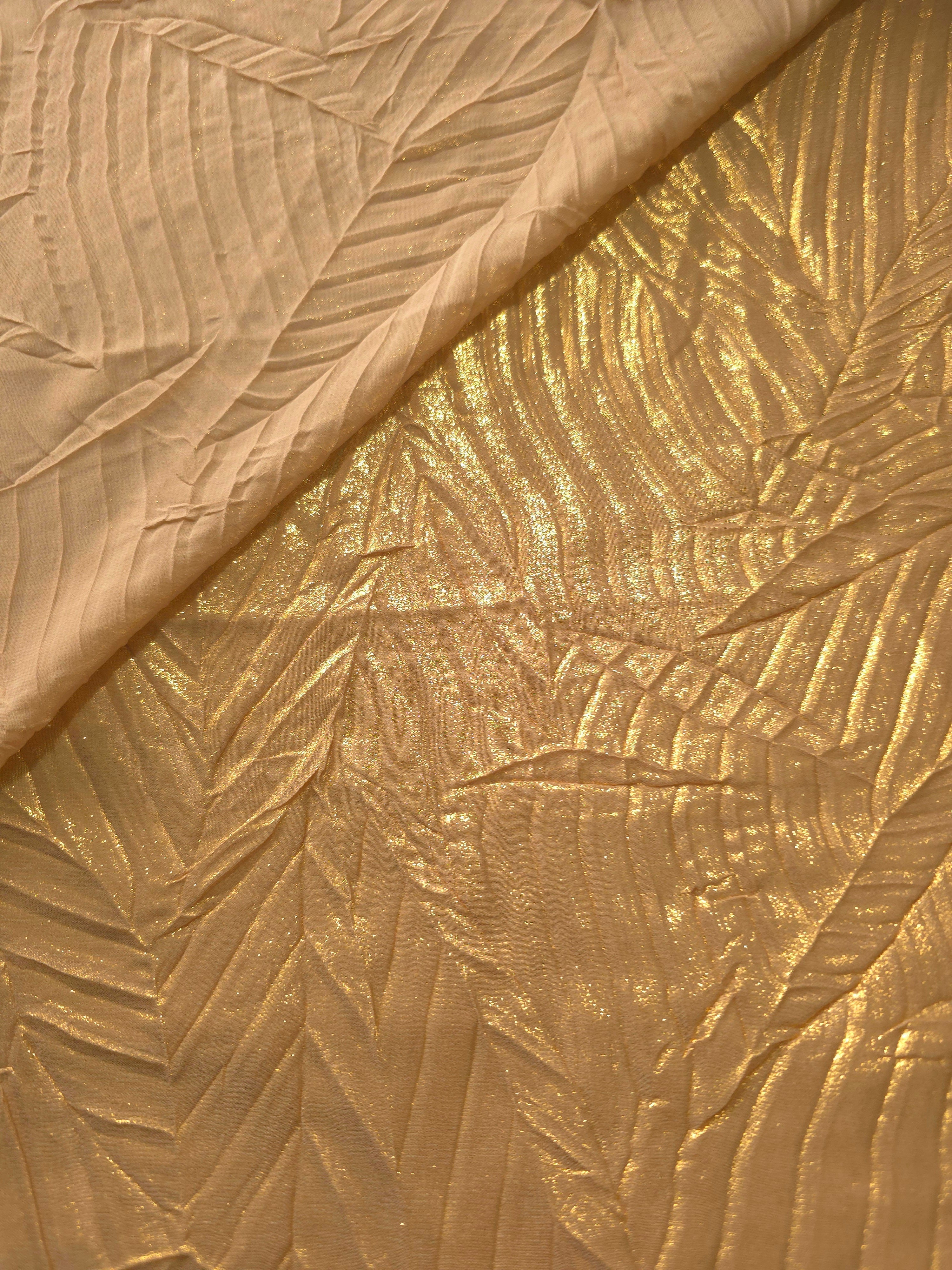 Fold detail of Bronze Gold leaf-pattern plissé fabric demonstrates how the textured surface builds depth for stagewear and layered fashion details.