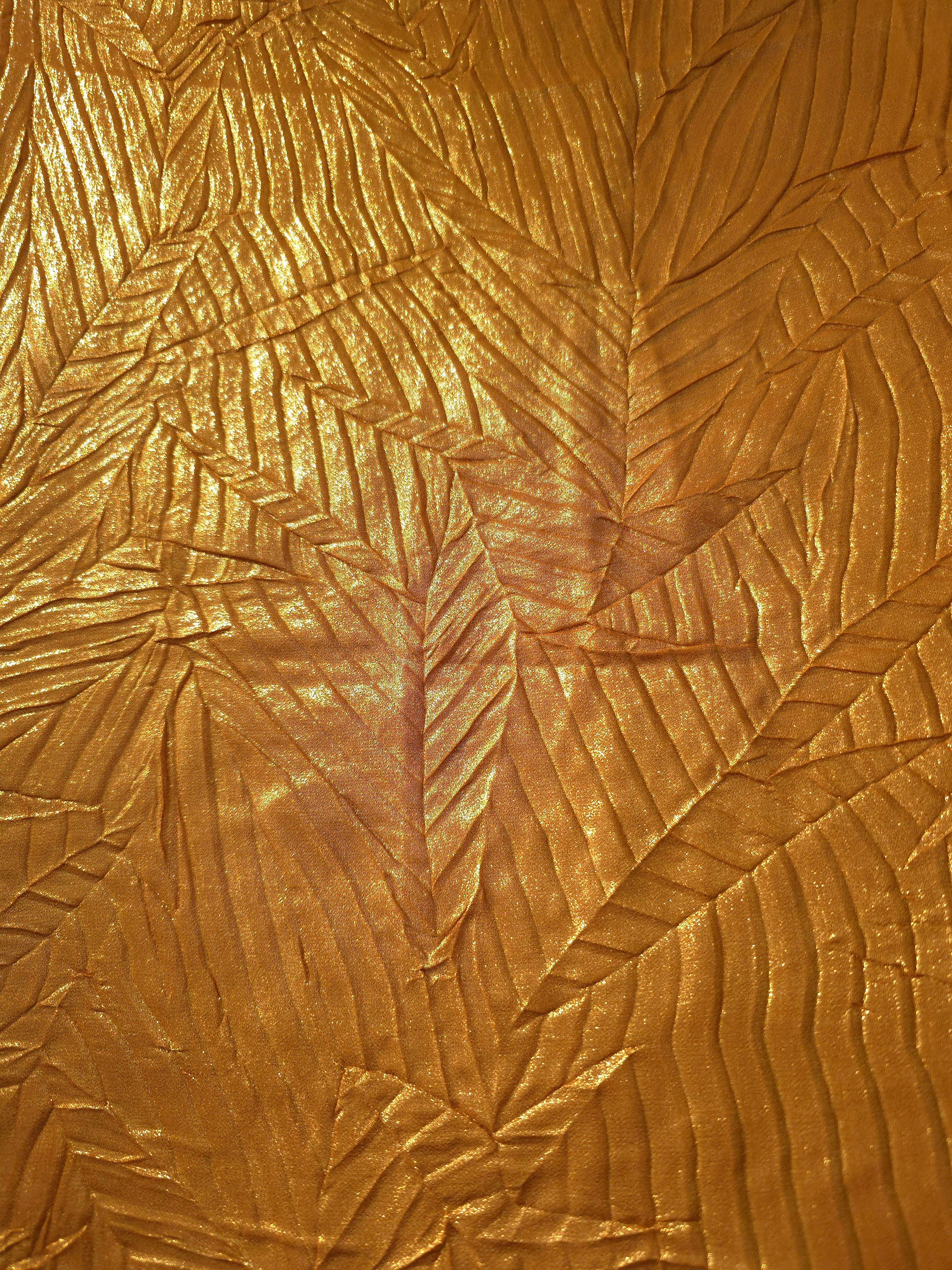 Surface detail of Burnished Copper leaf-pattern plissé shimmer fabric showcases sculpted leaf-like pleats for evening clutches, garment accents and special-occasion pieces.