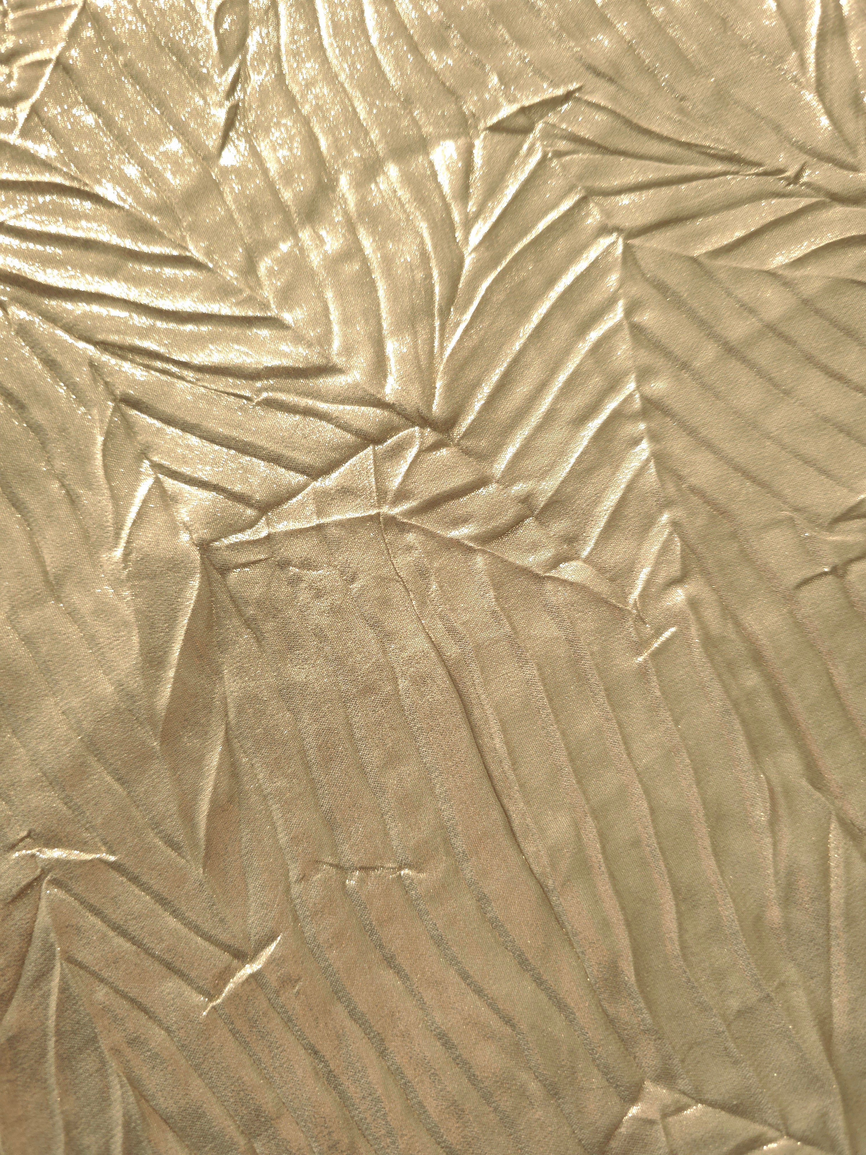 Soft drape of Champagne Beige textured shimmer plissé reveals dimensional folds and shifting reflection for formal tops and draped skirt designs.