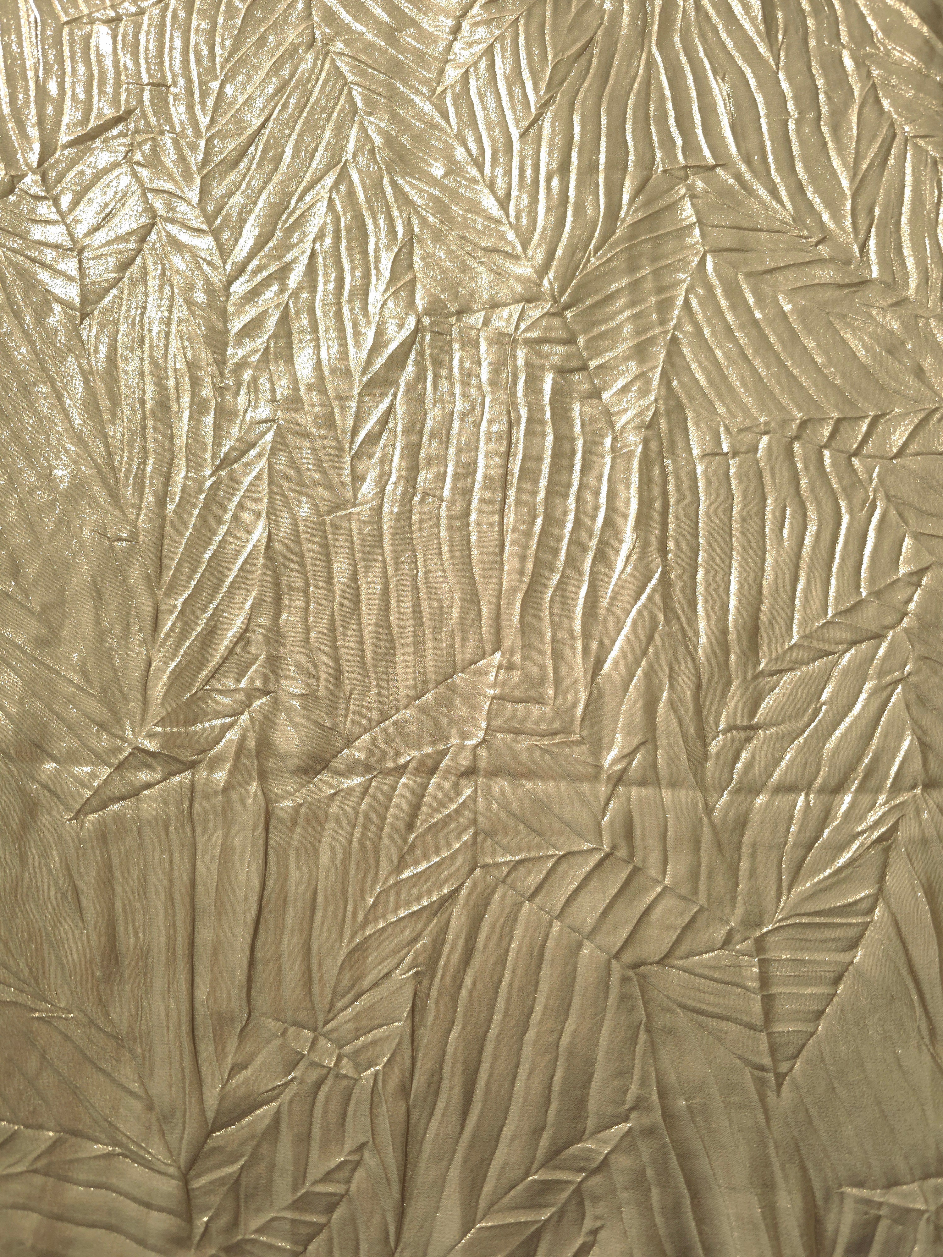 Surface detail of Champagne Beige leaf-pattern plissé shimmer fabric showcases sculpted leaf-like pleats for evening clutches, garment accents and special-occasion pieces.