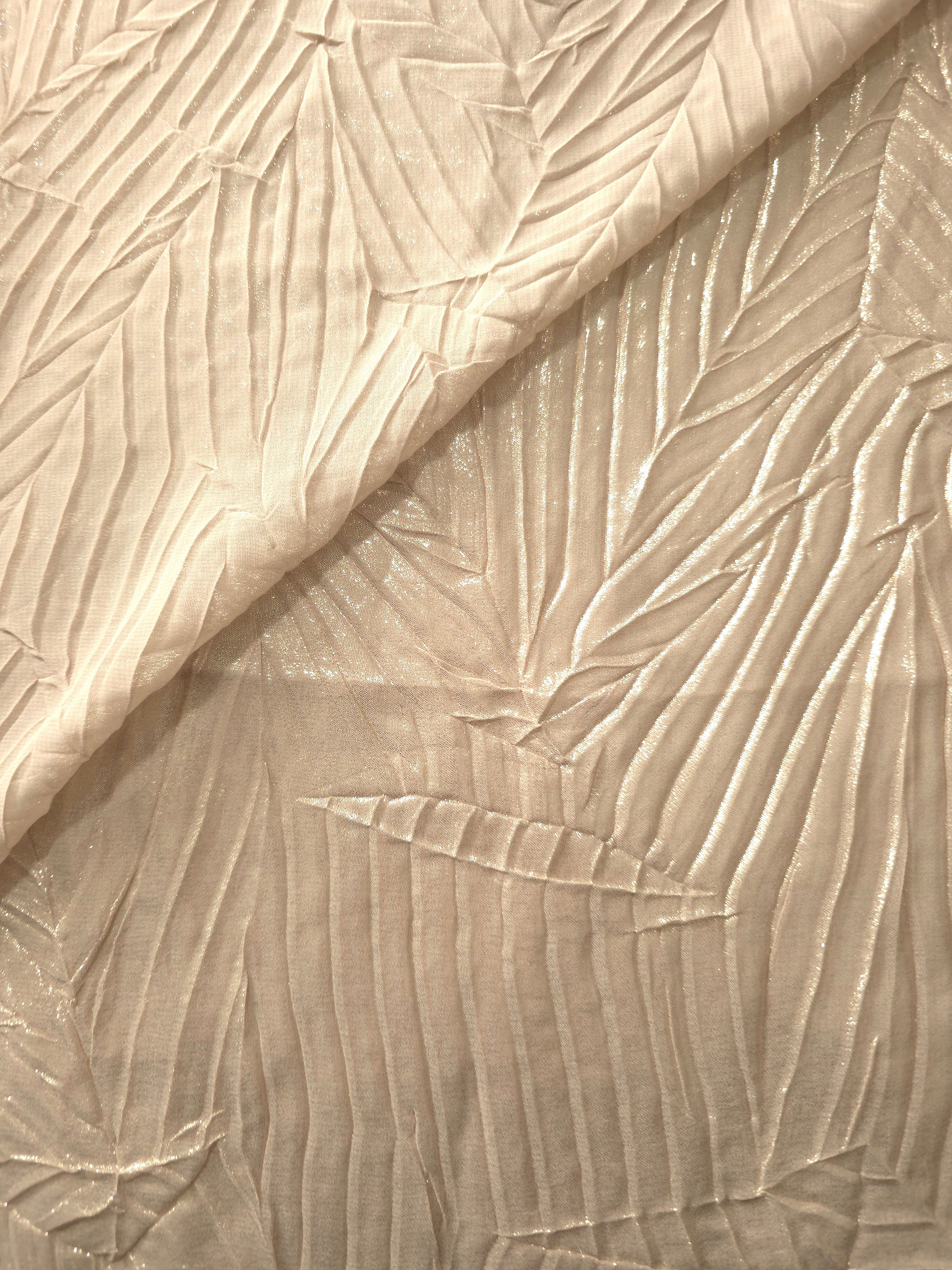Fold detail of Champagne Cream leaf-pattern plissé fabric demonstrates how the textured surface builds depth for stagewear and layered fashion details.