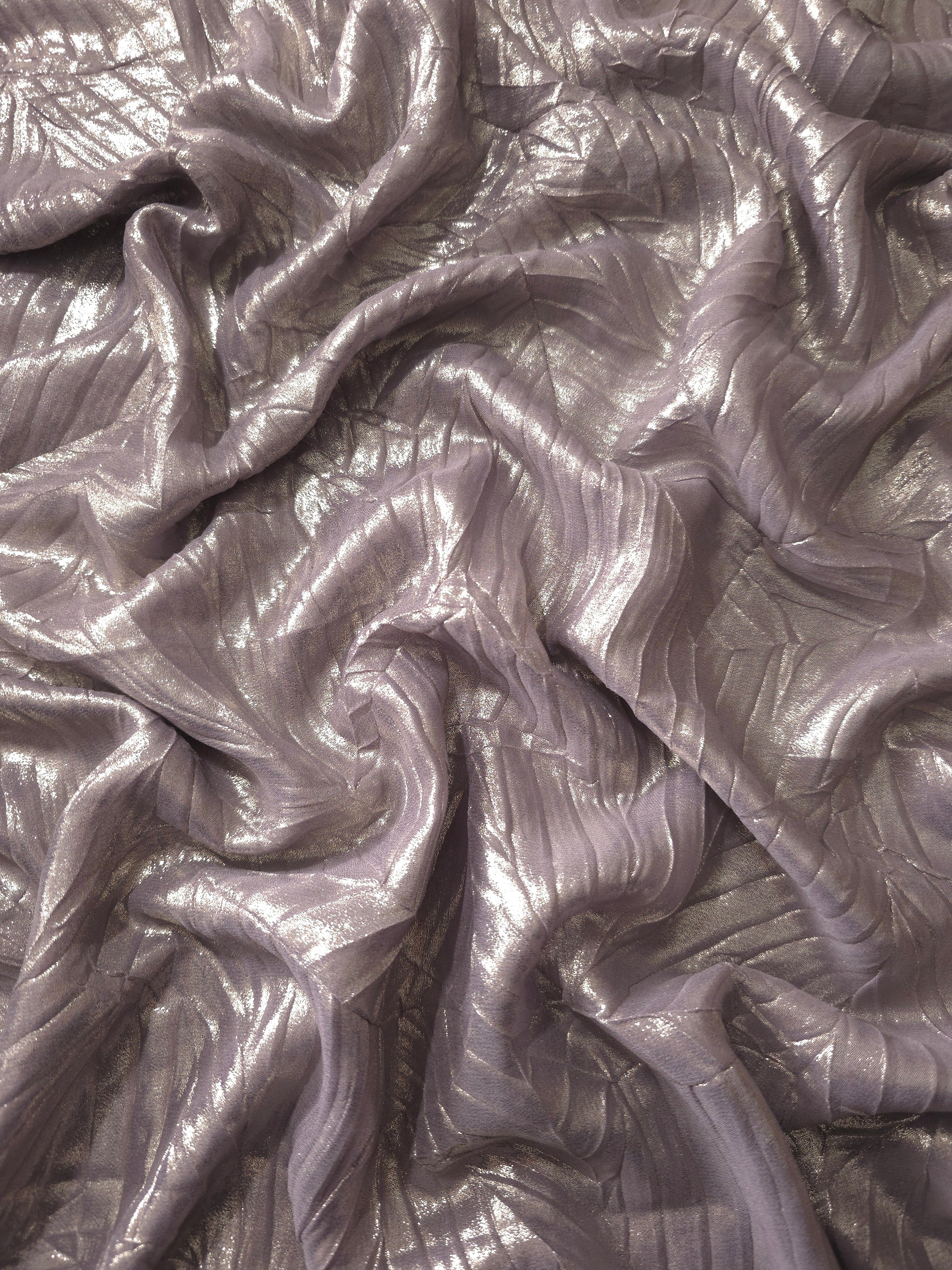 Flowing drape of Lavender Taupe leaf-pattern plissé shimmer fabric, showing sculpted leaf-like pleats and light-catching movement for evening gowns and flowing maxi skirts.