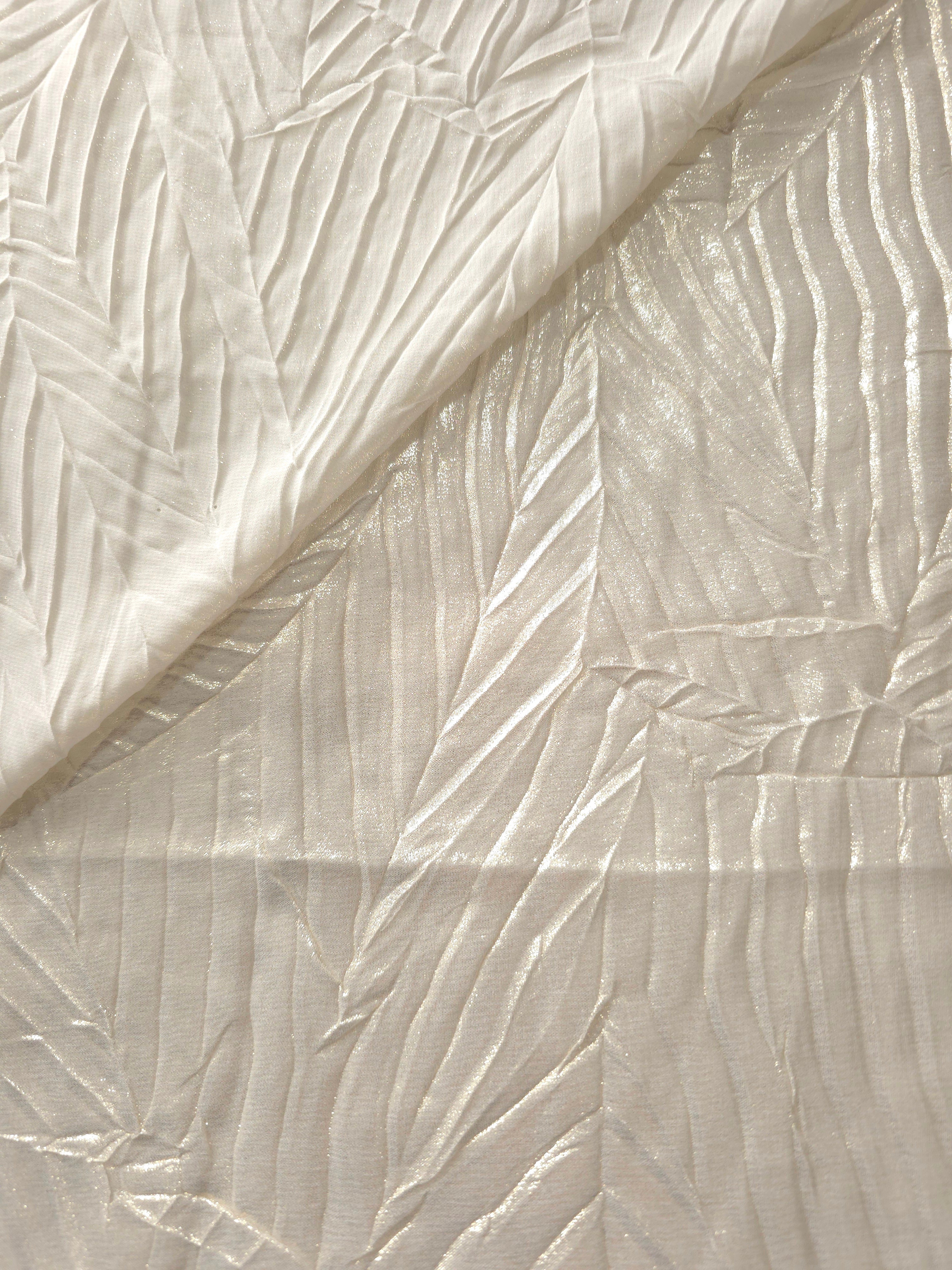 Fold detail of Pearl Ivory leaf-pattern plissé fabric demonstrates how the textured surface builds depth for stagewear and layered fashion details.