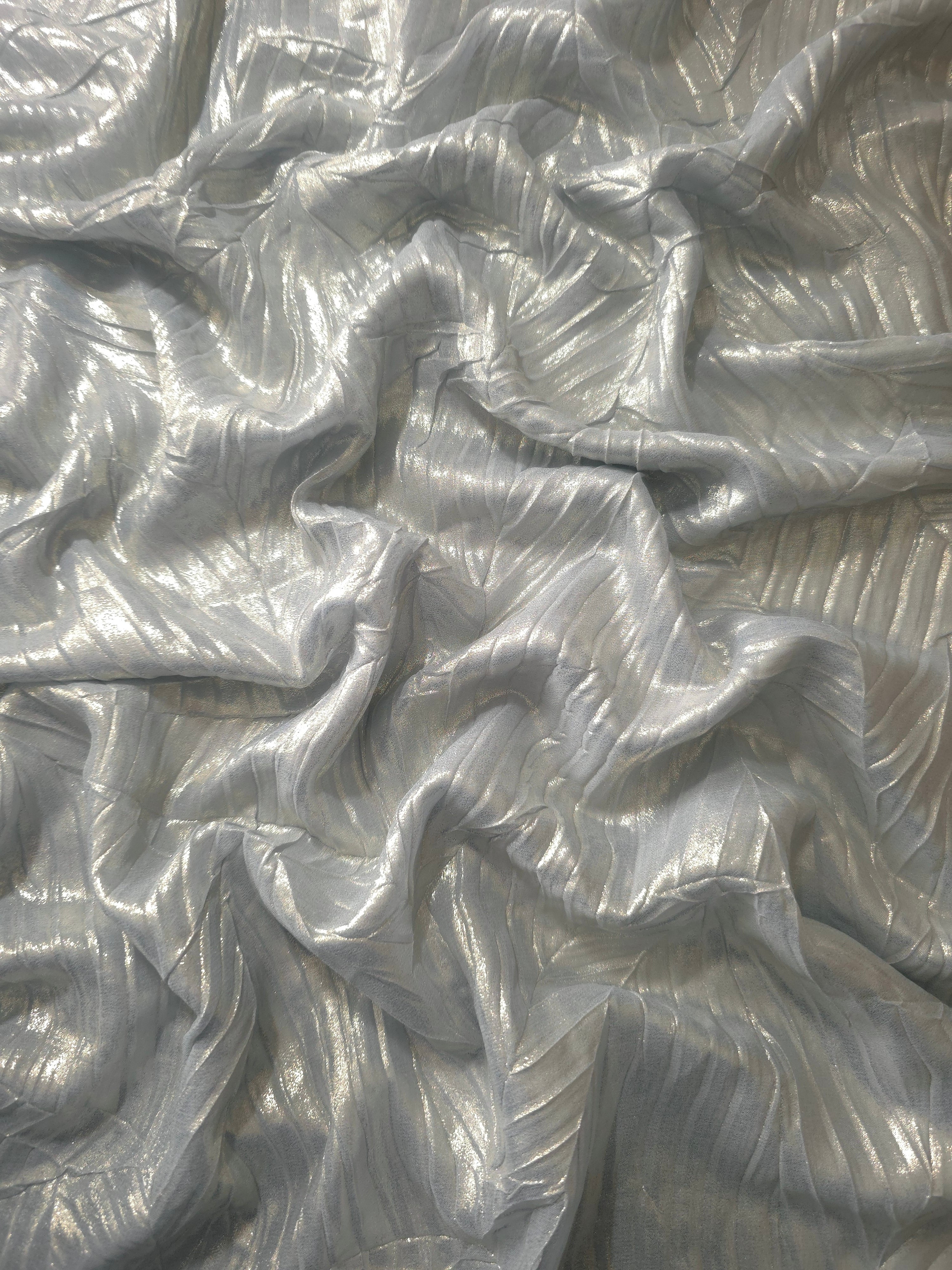 Flowing drape of Pewter Gray leaf-pattern plissé shimmer fabric, showing sculpted leaf-like pleats and light-catching movement for evening gowns and flowing maxi skirts.