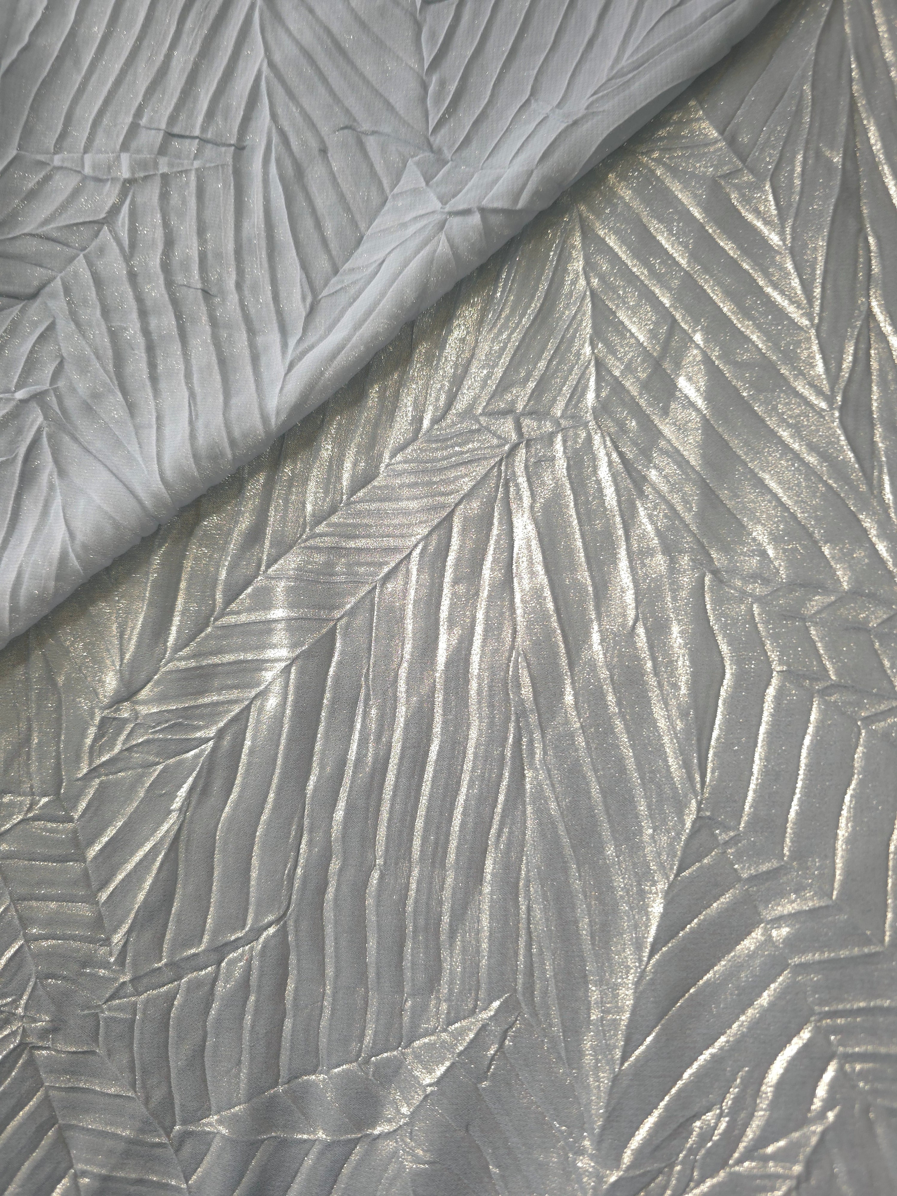 Fold detail of Pewter Gray leaf-pattern plissé fabric demonstrates how the textured surface builds depth for stagewear and layered fashion details.