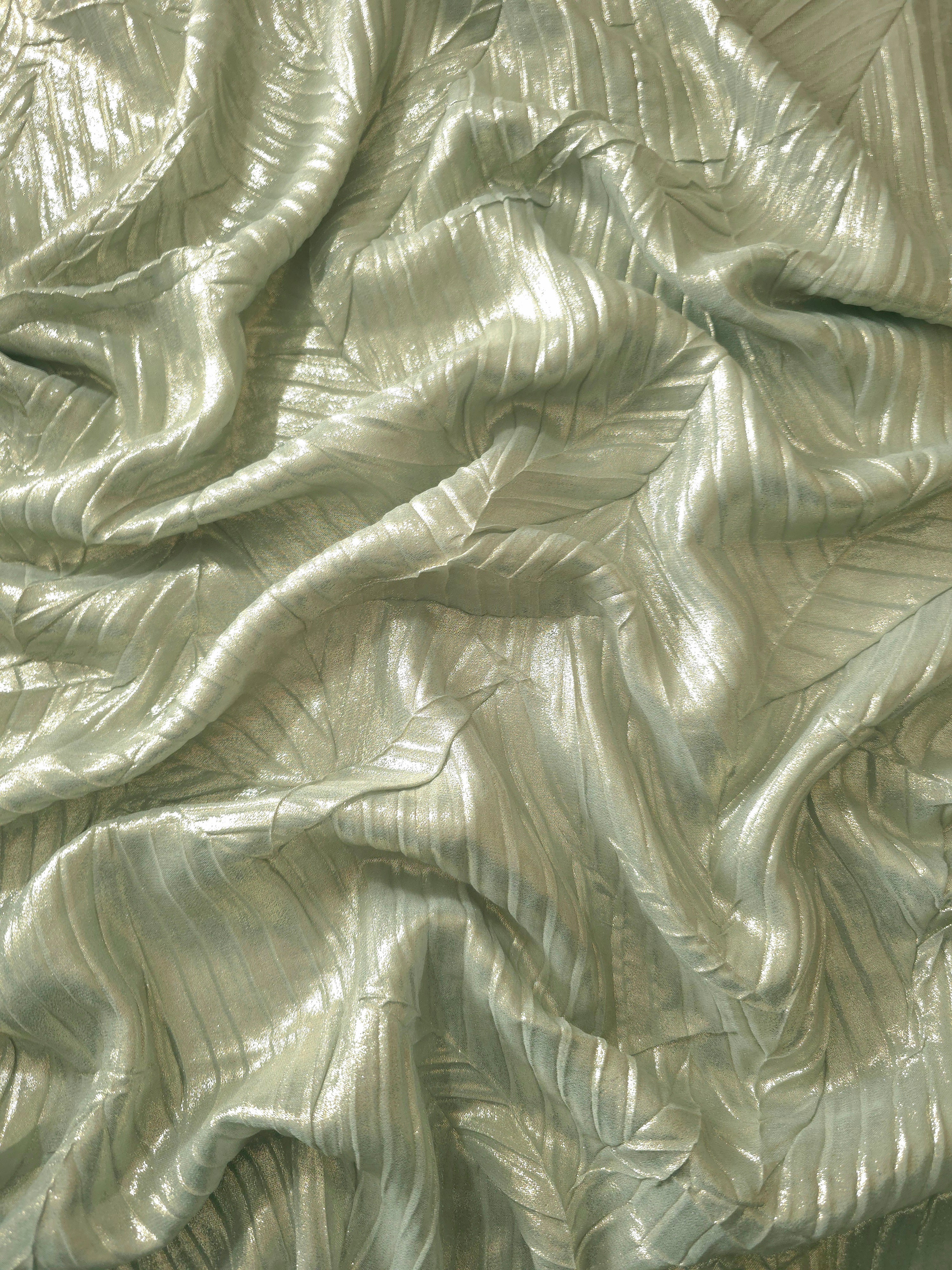 Flowing drape of Sage Gray leaf-pattern plissé shimmer fabric, showing sculpted leaf-like pleats and light-catching movement for evening gowns and flowing maxi skirts.