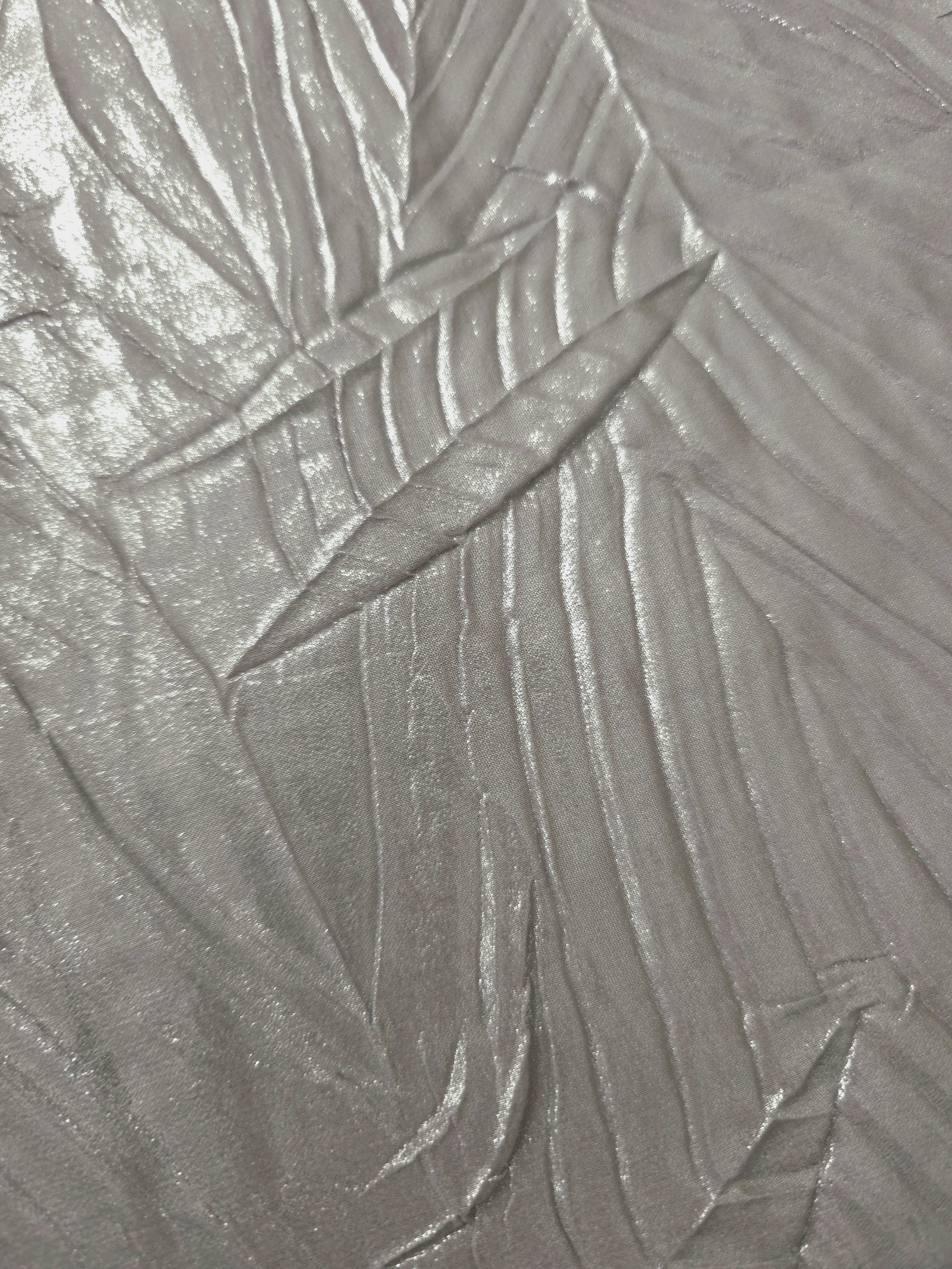 Soft drape of Steel Silver textured shimmer plissé reveals dimensional folds and shifting reflection for jumpsuits and fluid occasionwear.