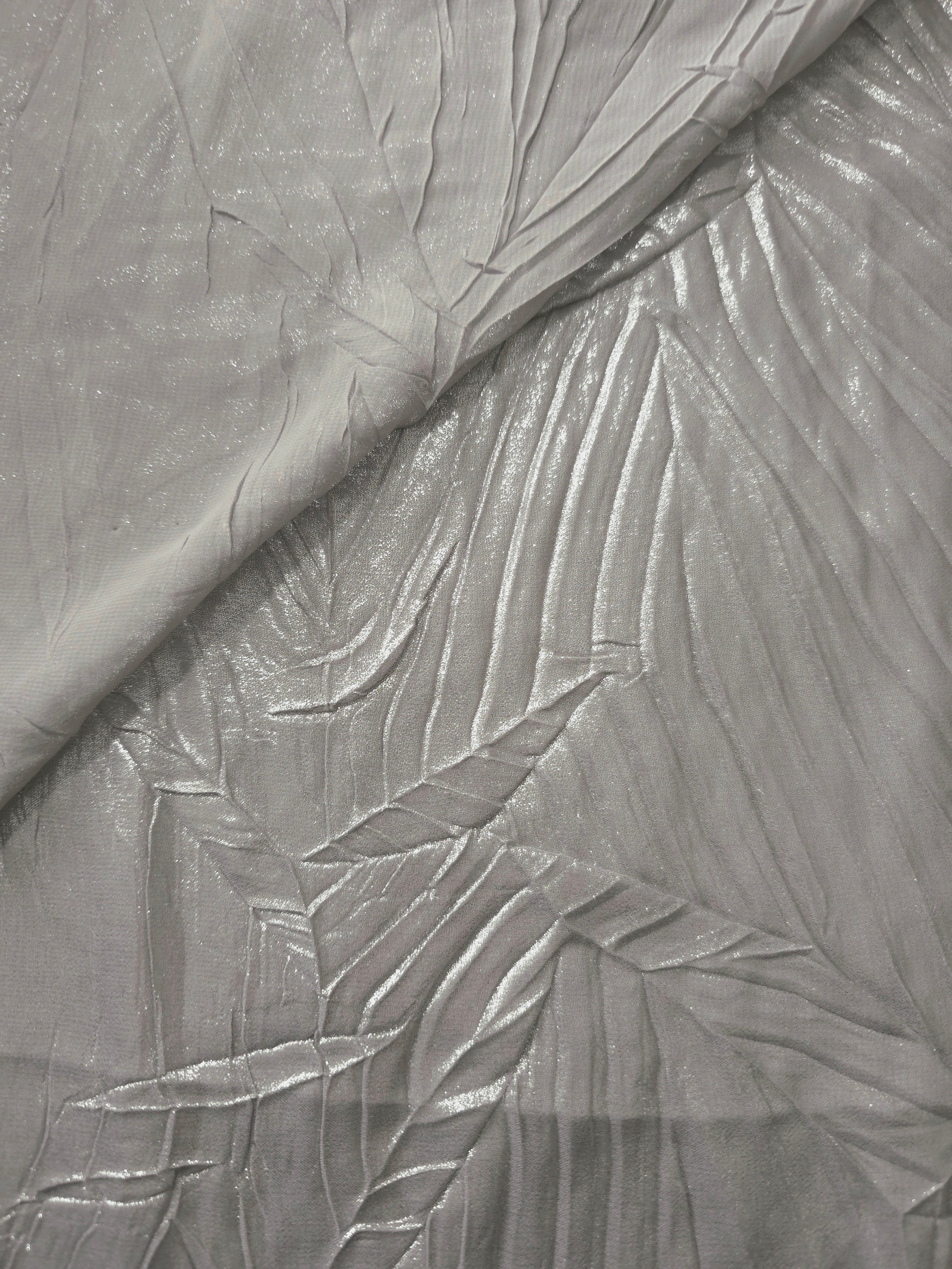 Fold detail of Steel Silver leaf-pattern plissé fabric demonstrates how the textured surface builds depth for stagewear and layered fashion details.
