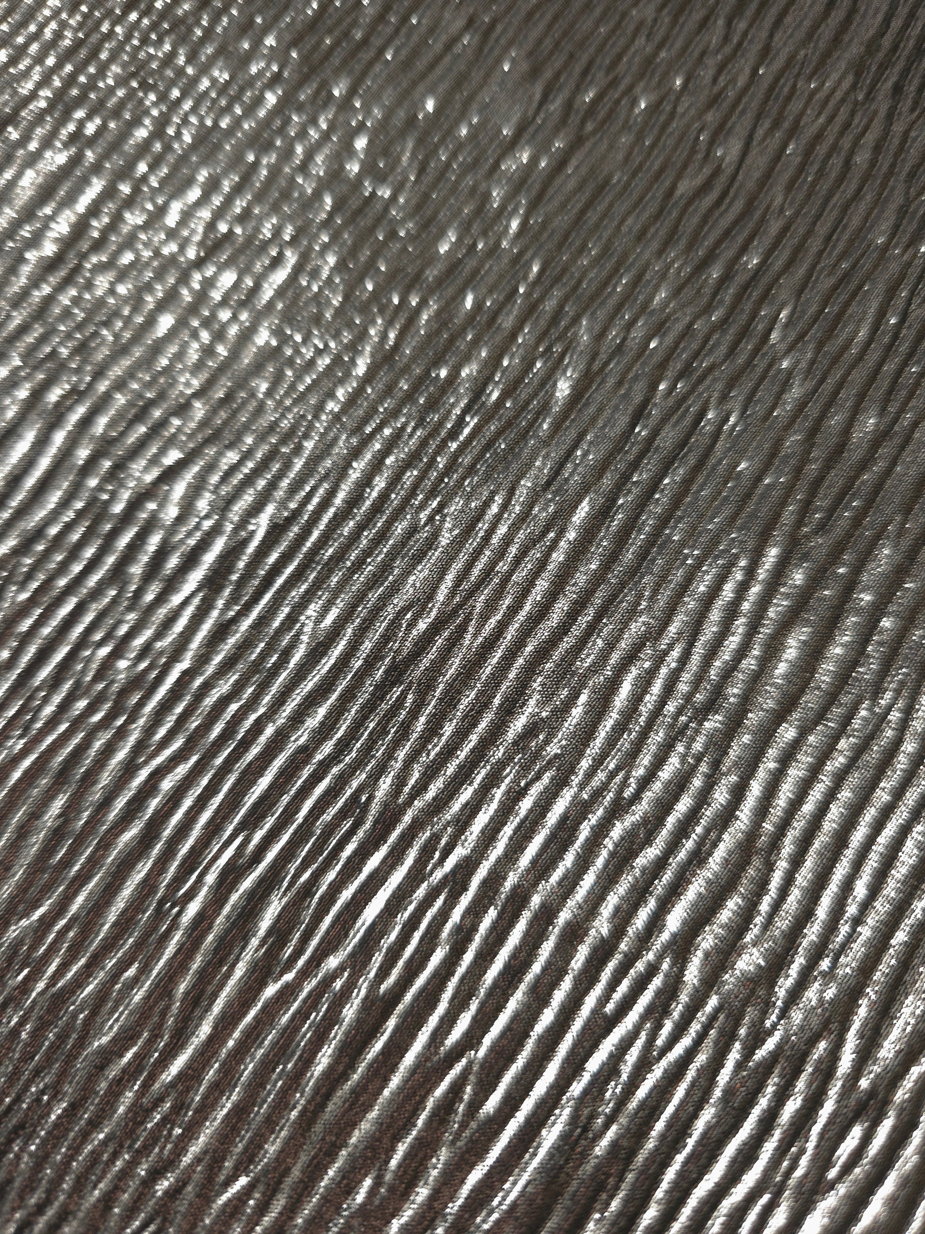 Soft drape of Graphite Gray textured shimmer plissé reveals dimensional folds and shifting reflection for formal tops and draped skirt designs.