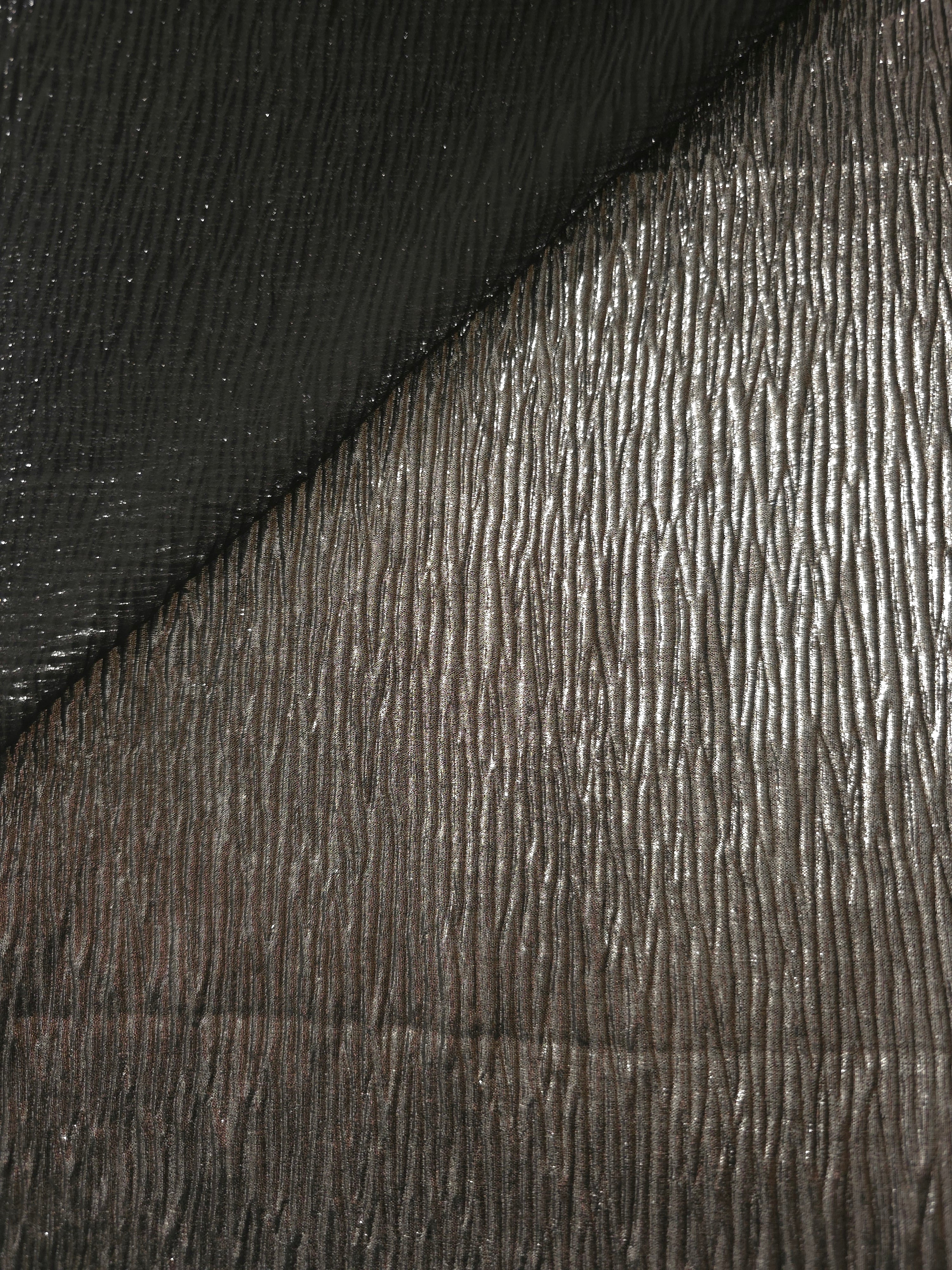 Fold detail of Graphite Gray fine mini-plissé fabric demonstrates how the textured surface builds depth for stagewear and layered fashion details.