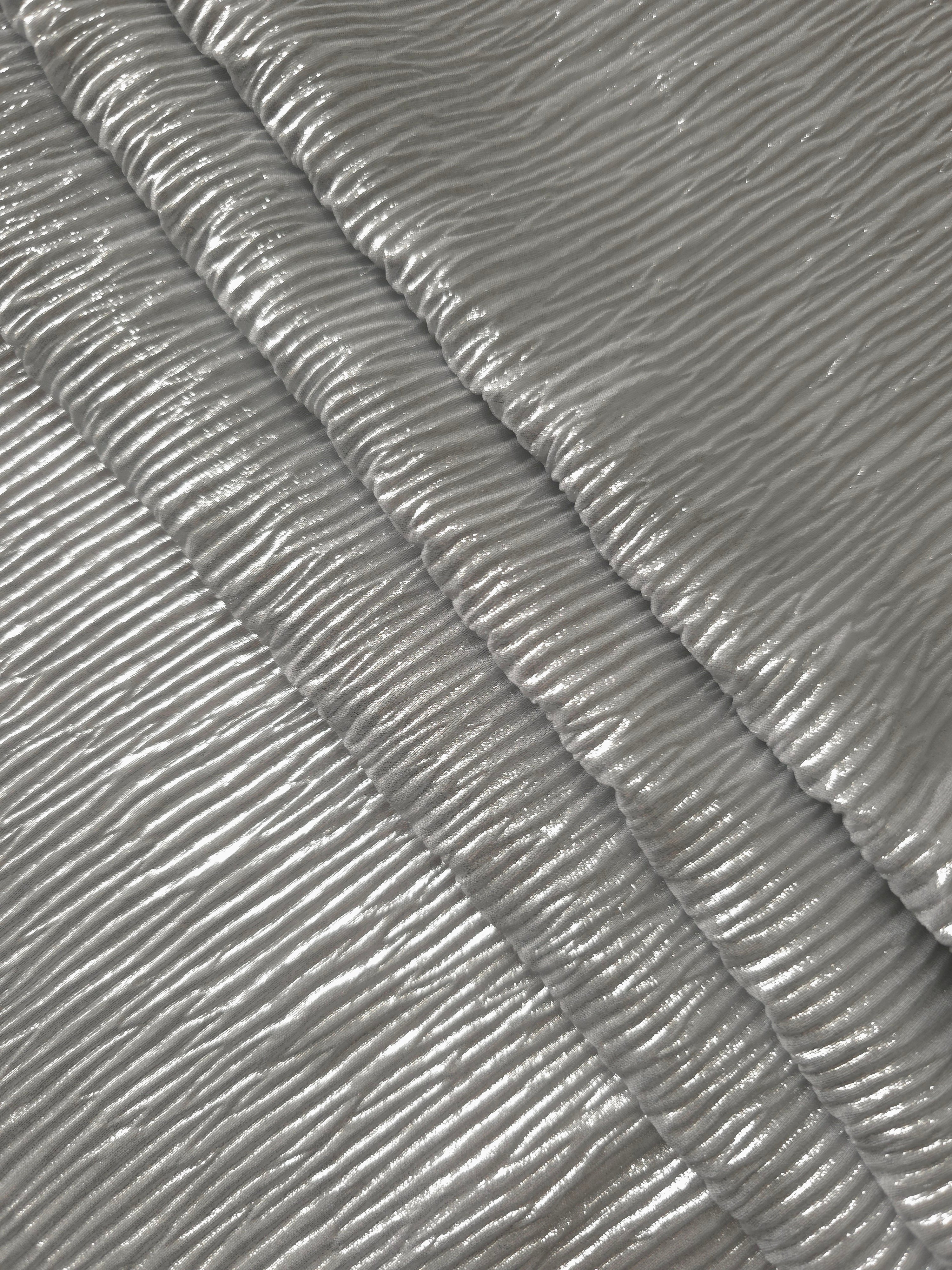 Soft drape of Pearl Silver textured shimmer plissé reveals dimensional folds and shifting reflection for formal tops and draped skirt designs.