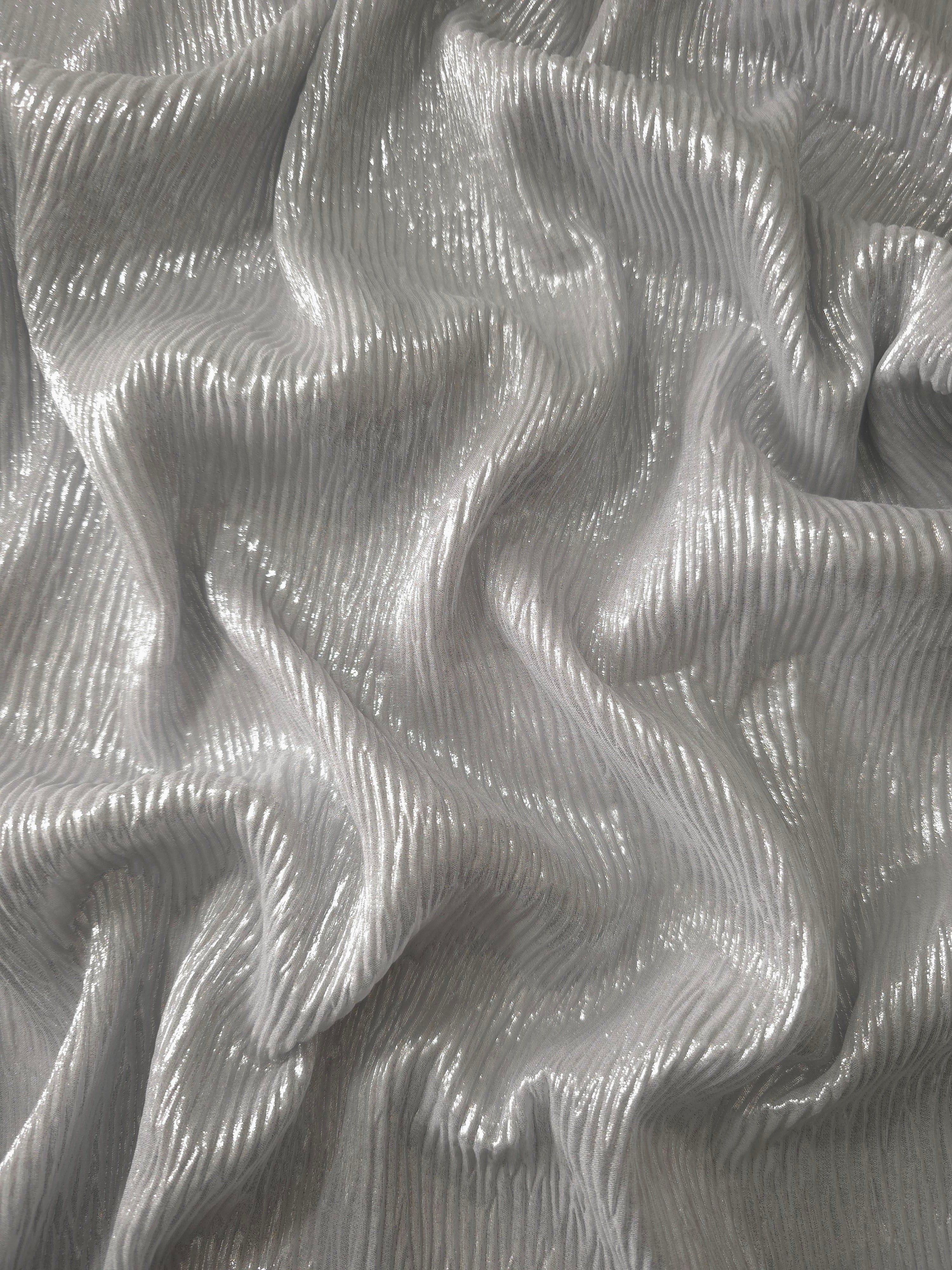 Flowing drape of Pearl Silver fine mini-plissé shimmer fabric, showing narrow micro-pleated texture and light-catching movement for evening gowns and flowing maxi skirts.