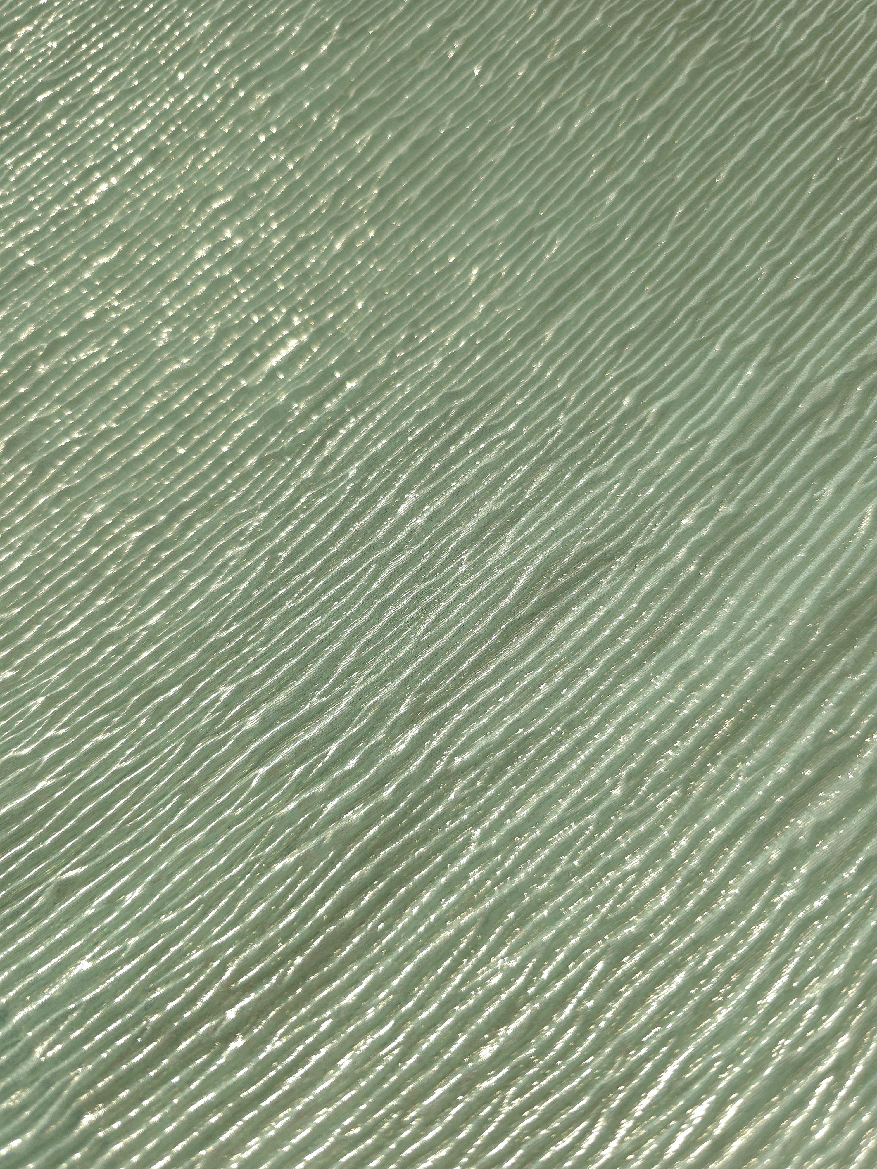 Soft drape of Soft Sage textured shimmer plissé reveals dimensional folds and shifting reflection for formal tops and draped skirt designs.
