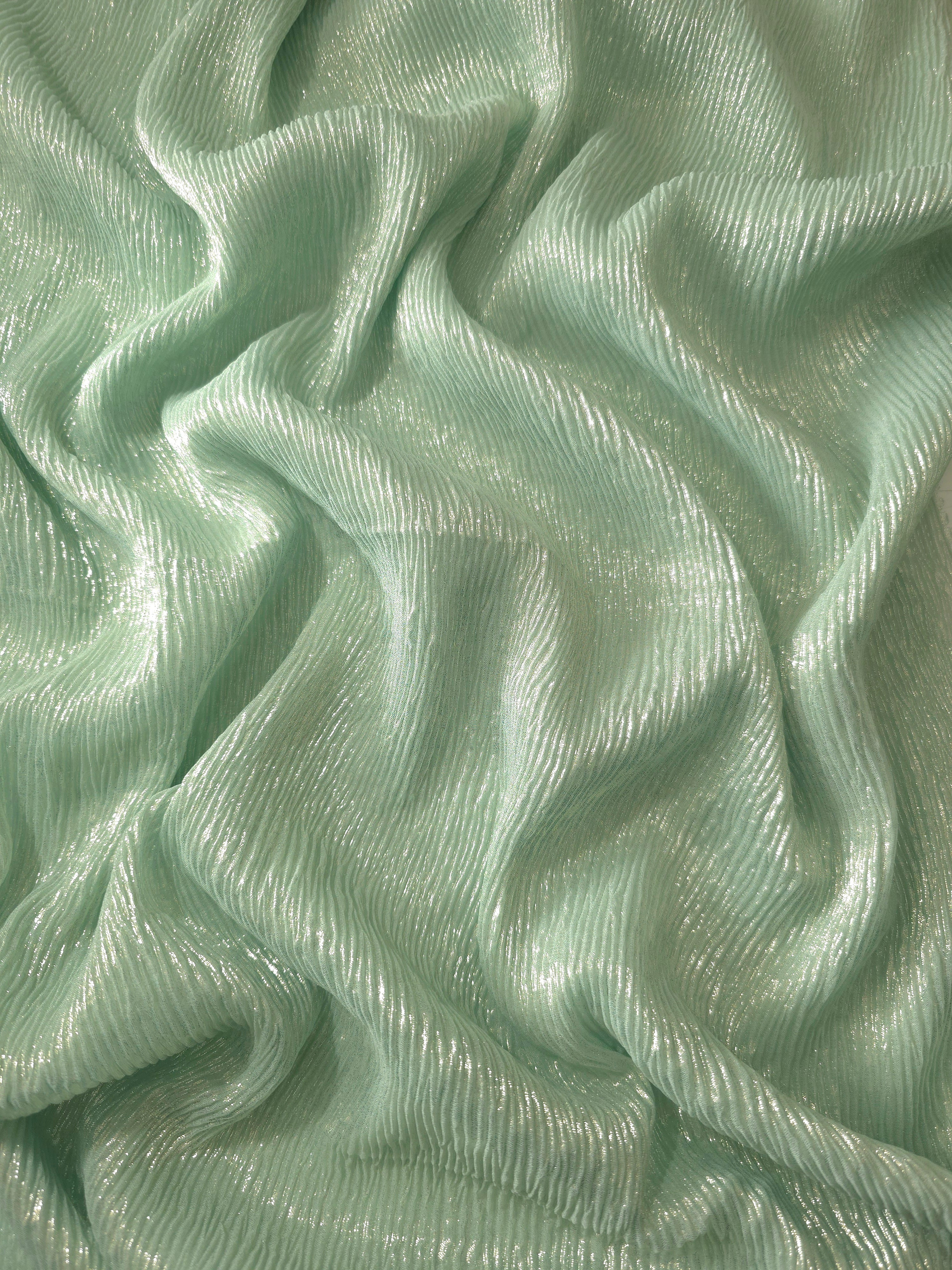 Flowing drape of Soft Sage fine mini-plissé shimmer fabric, showing narrow micro-pleated texture and light-catching movement for evening gowns and flowing maxi skirts.