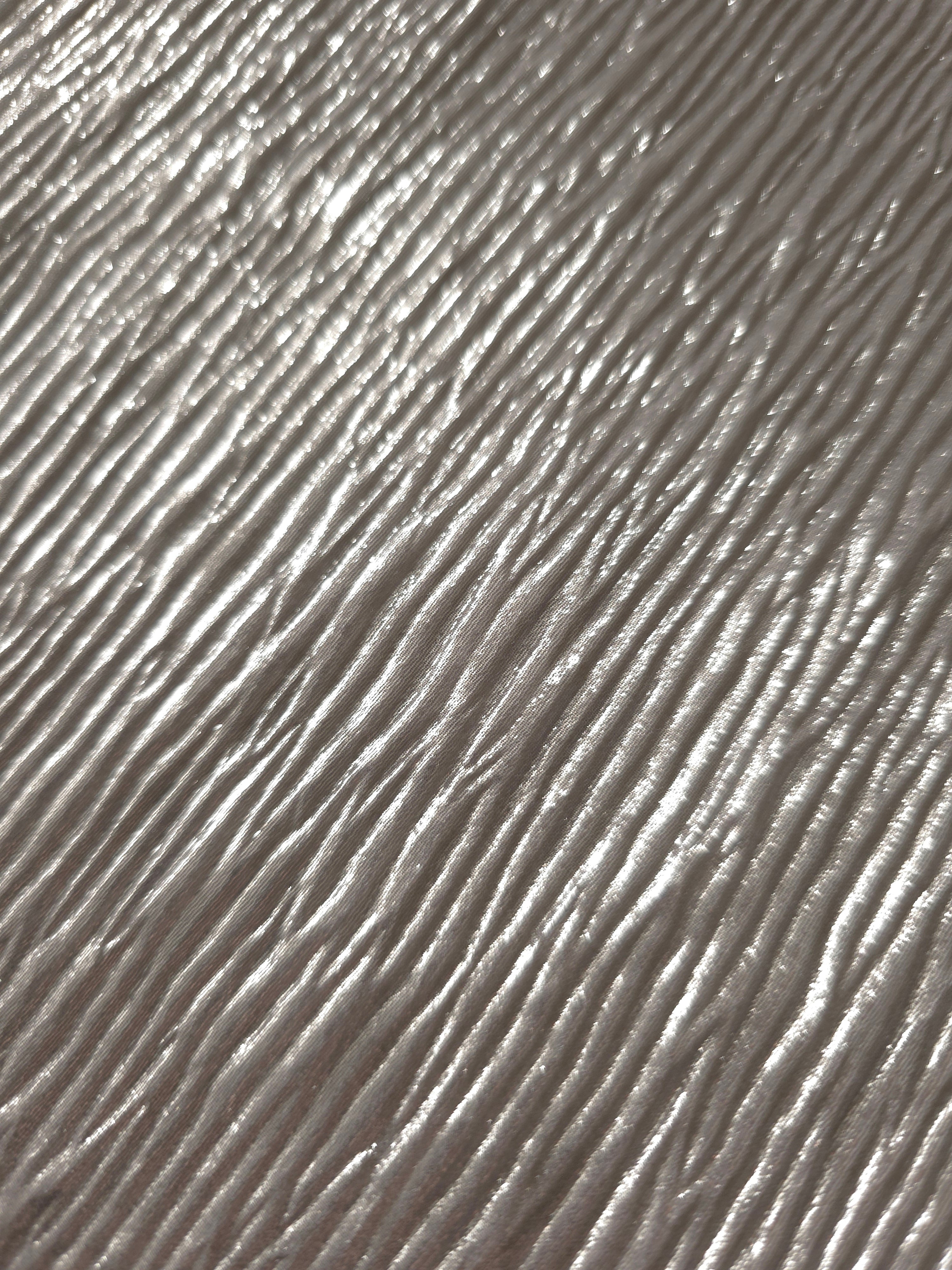 Soft drape of Steel Silver textured shimmer plissé reveals dimensional folds and shifting reflection for formal tops and draped skirt designs.