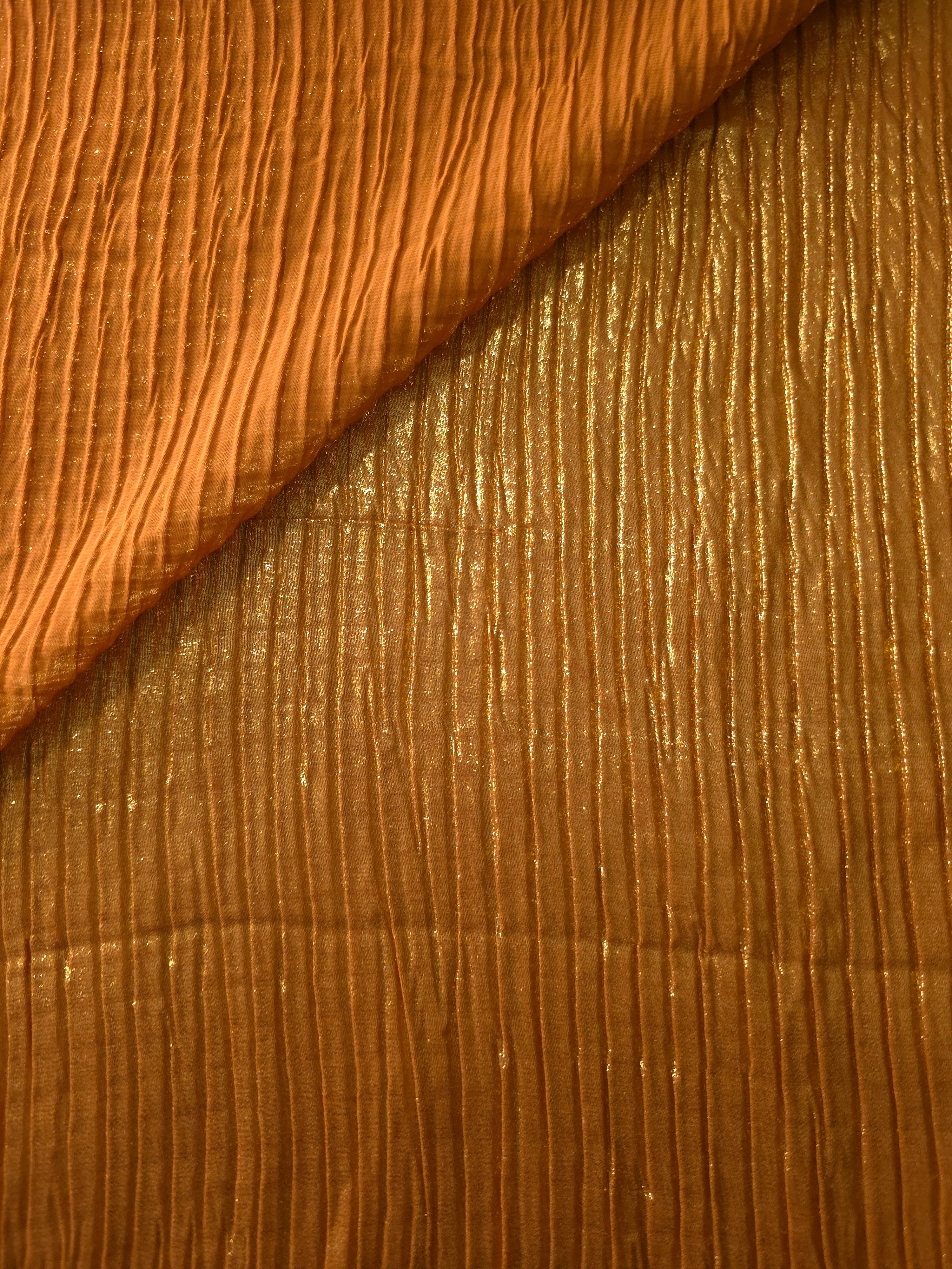 Fold detail of Amber Gold classic plissé fabric demonstrates how the textured surface builds depth for stagewear and layered fashion details.