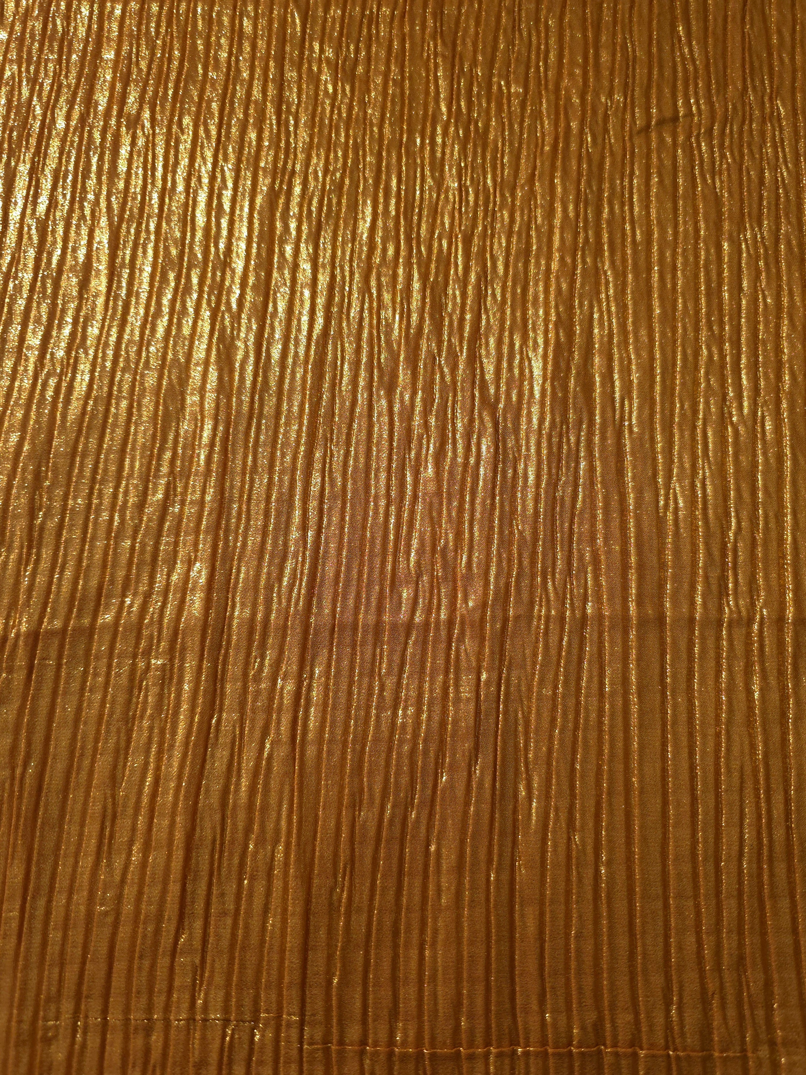 Surface detail of Amber Gold classic plissé shimmer fabric showcases regular pleated texture for evening clutches, garment accents and special-occasion pieces.