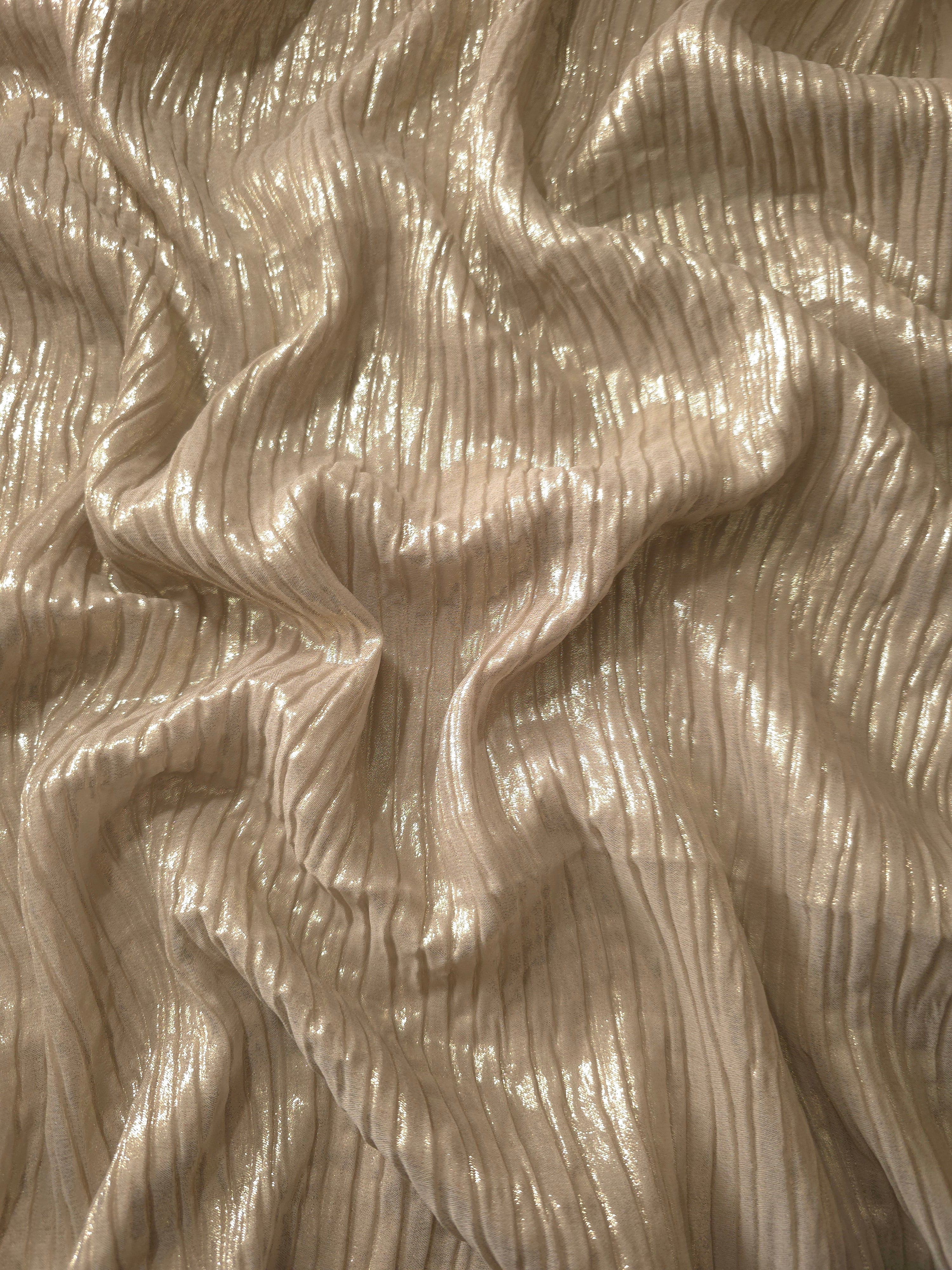 Flowing drape of Champagne Beige classic plissé shimmer fabric, showing regular pleated texture and light-catching movement for evening gowns and flowing maxi skirts.