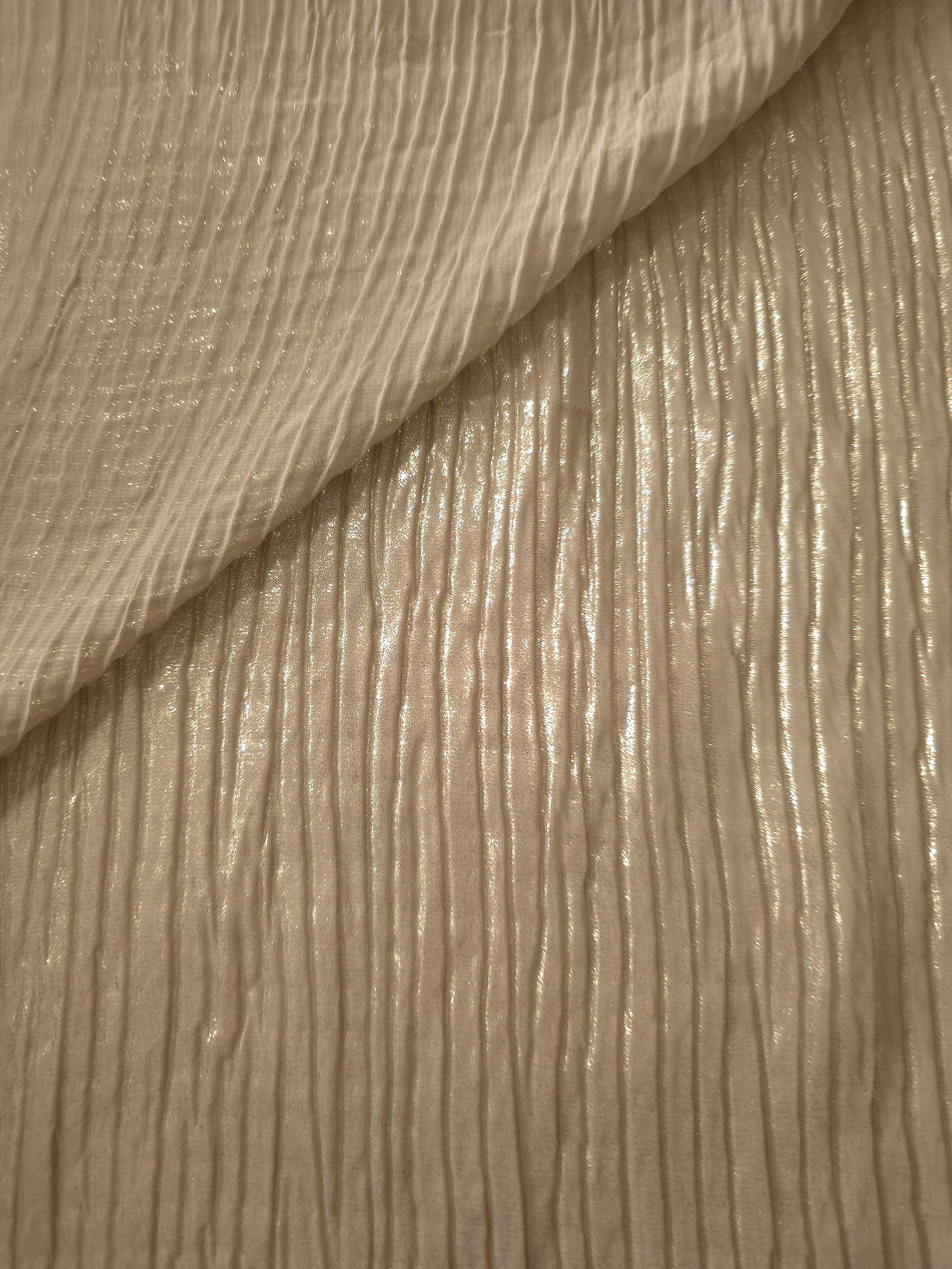 Fold detail of Champagne Beige classic plissé fabric demonstrates how the textured surface builds depth for stagewear and layered fashion details.