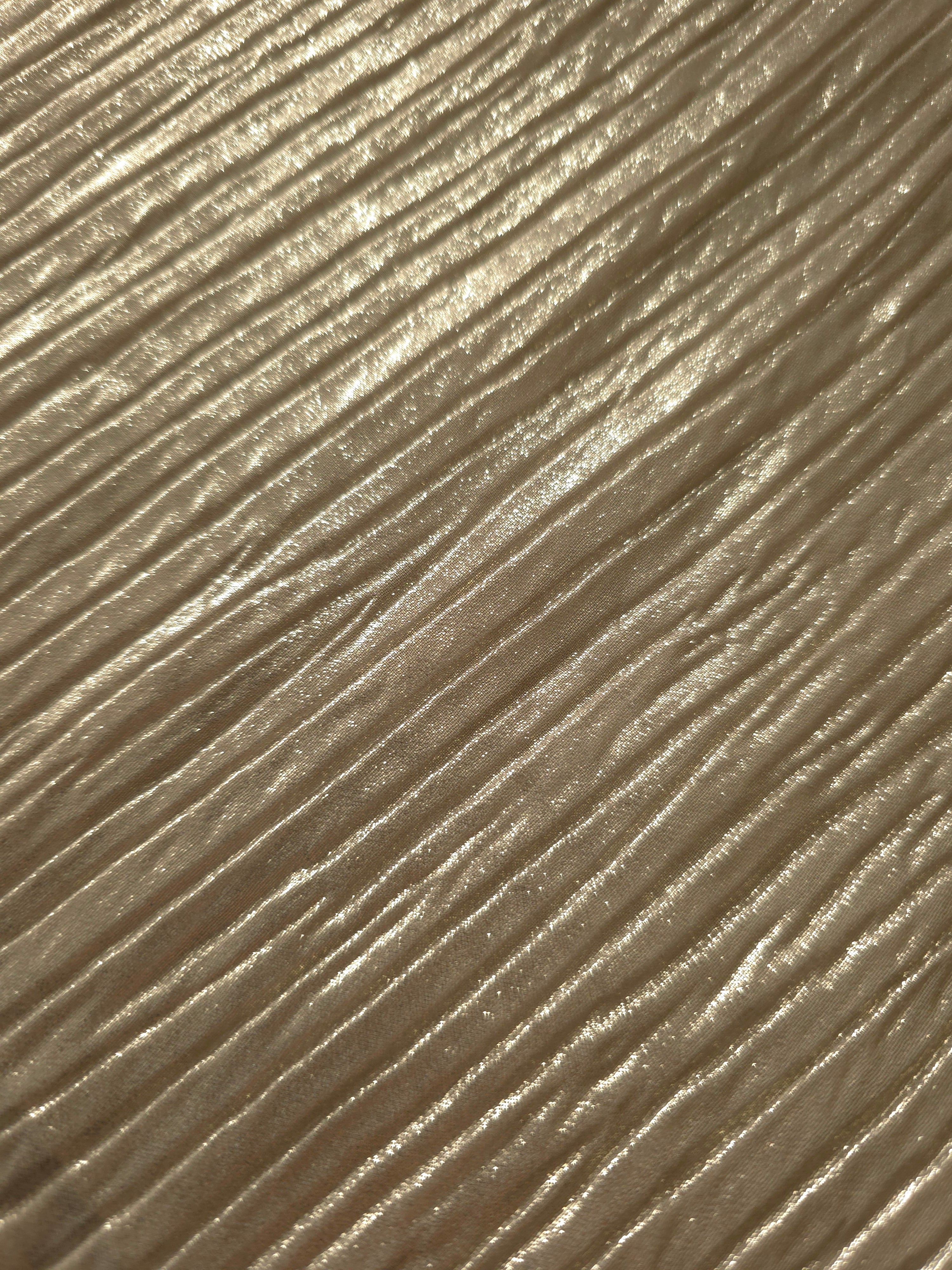 Soft drape of Champagne Taupe textured shimmer plissé reveals dimensional folds and shifting reflection for jumpsuits and fluid occasionwear.