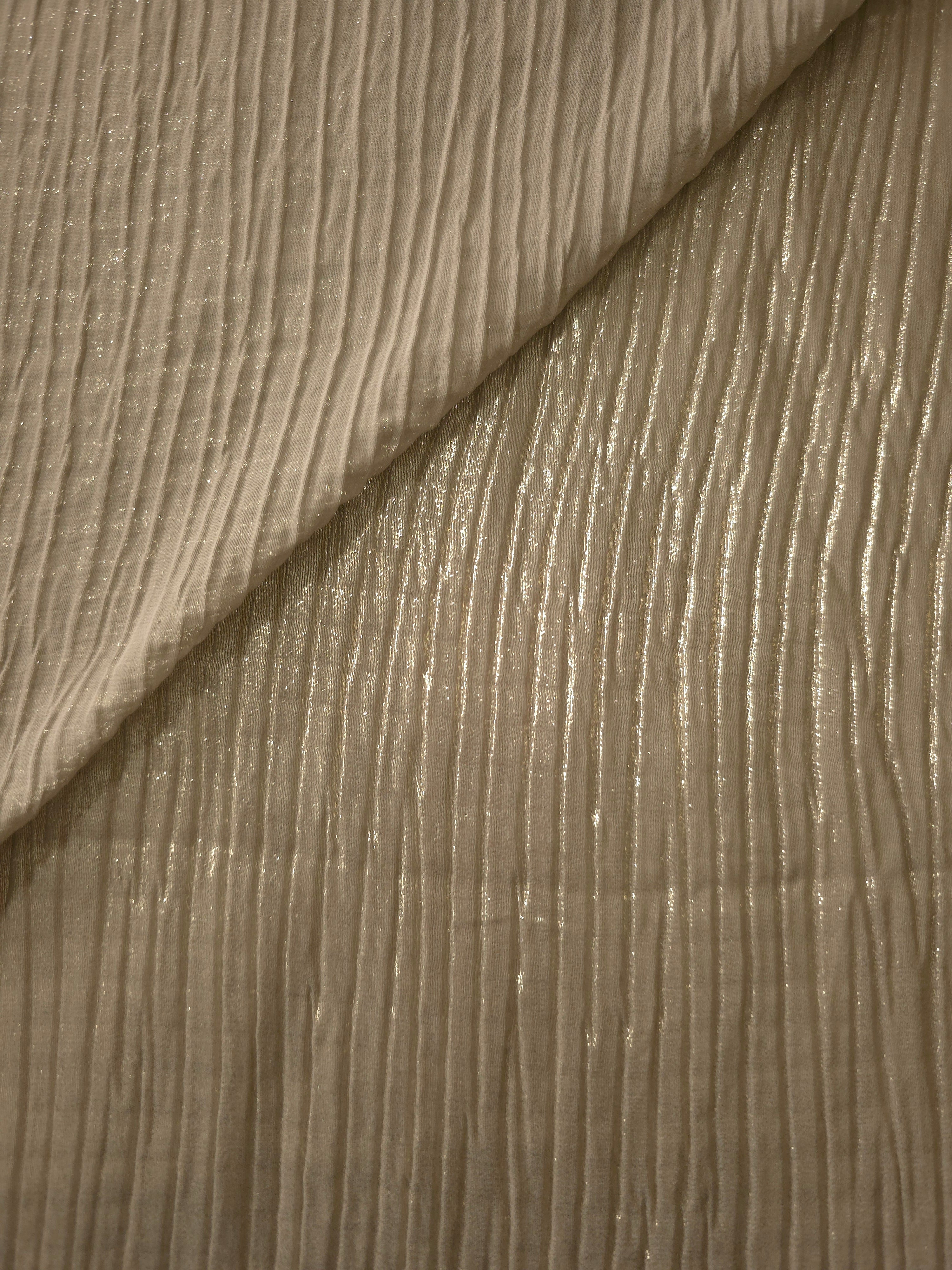 Fold detail of Champagne Taupe classic plissé fabric demonstrates how the textured surface builds depth for stagewear and layered fashion details.
