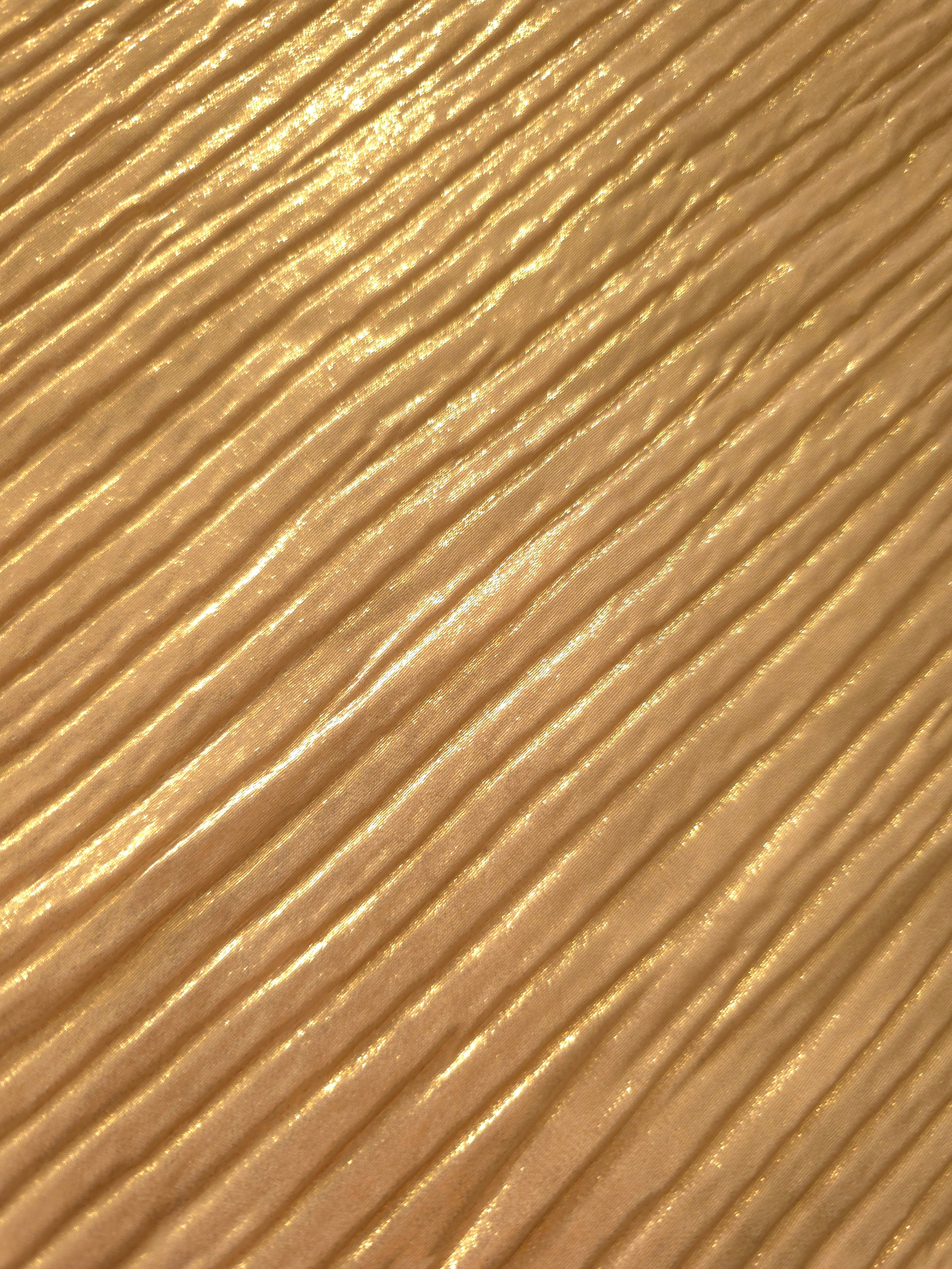 Soft drape of Golden Beige textured shimmer plissé reveals dimensional folds and shifting reflection for jumpsuits and fluid occasionwear.