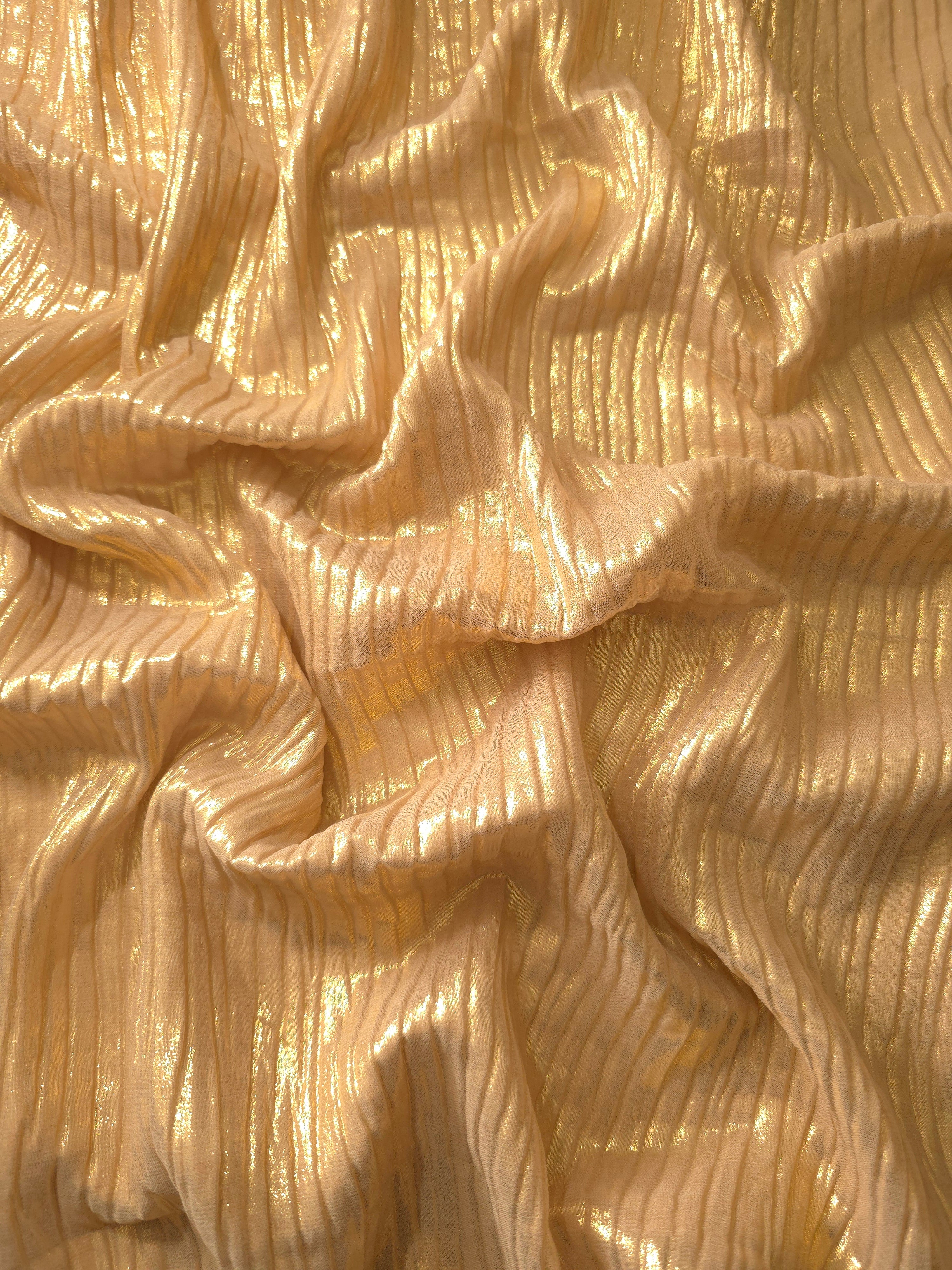 Flowing drape of Golden Beige classic plissé shimmer fabric, showing regular pleated texture and light-catching movement for evening gowns and flowing maxi skirts.