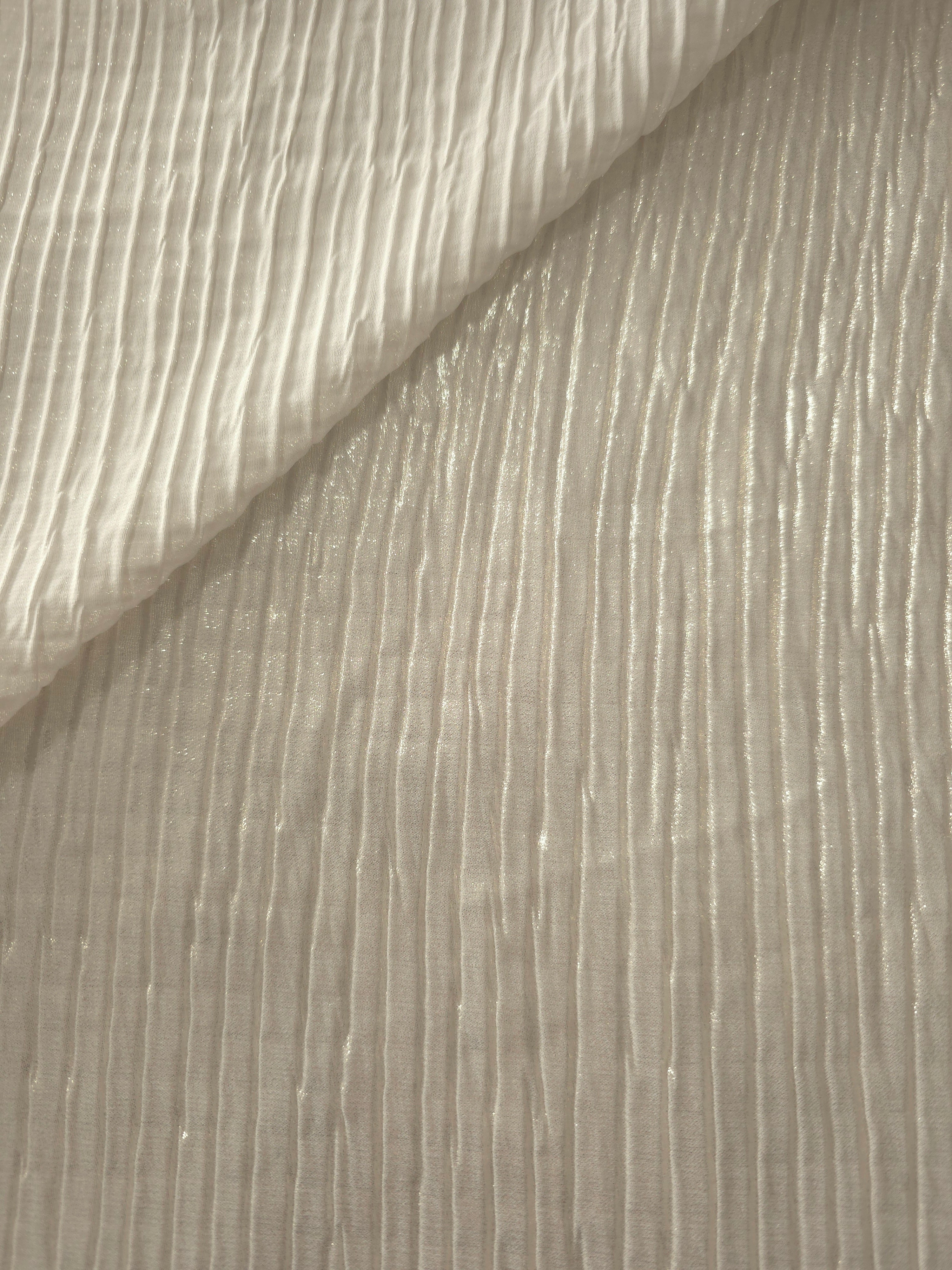 Fold detail of Ivory Cream classic plissé fabric demonstrates how the textured surface builds depth for stagewear and layered fashion details.