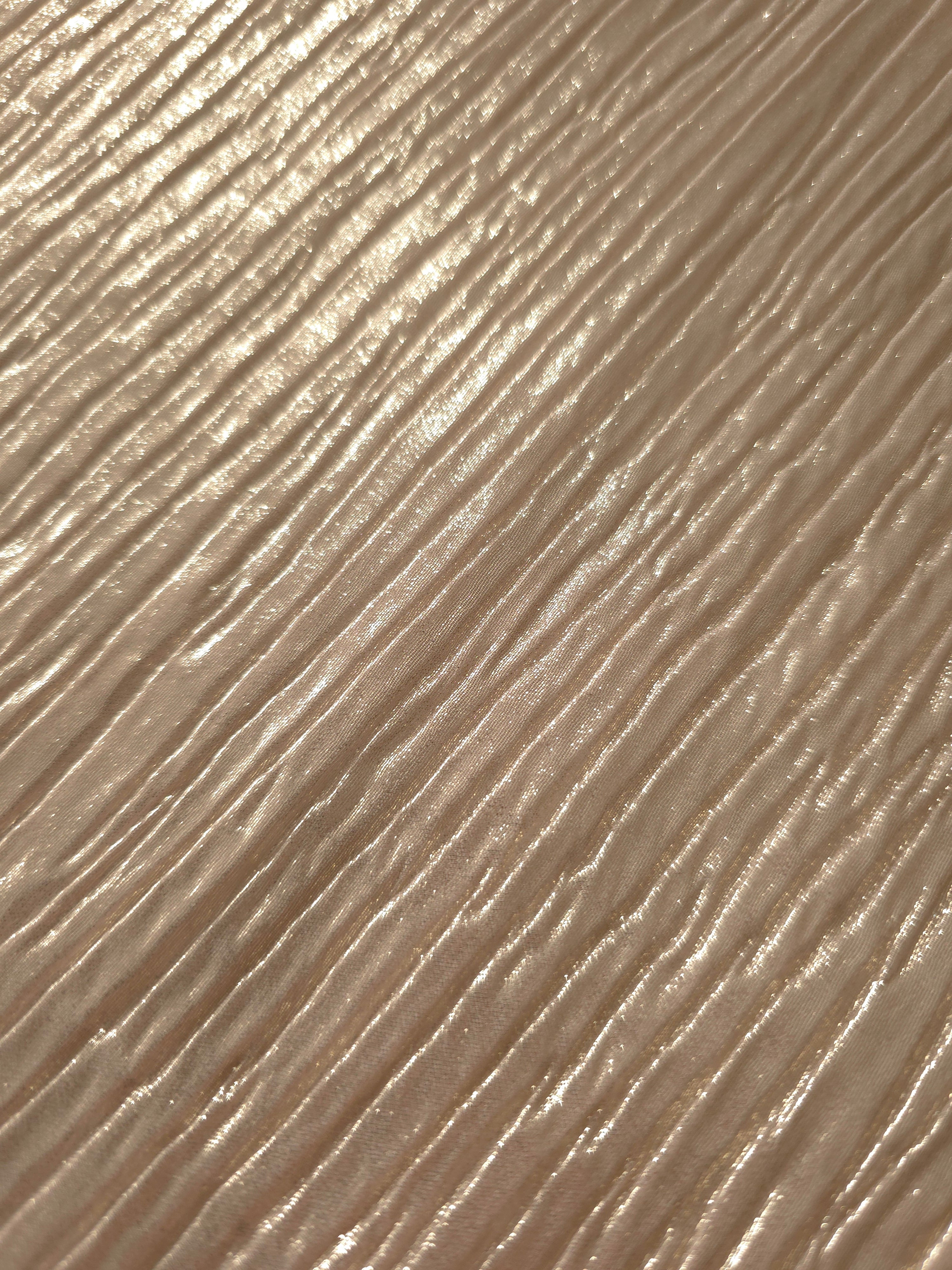 Soft drape of Light Cream textured shimmer plissé reveals dimensional folds and shifting reflection for jumpsuits and fluid occasionwear.