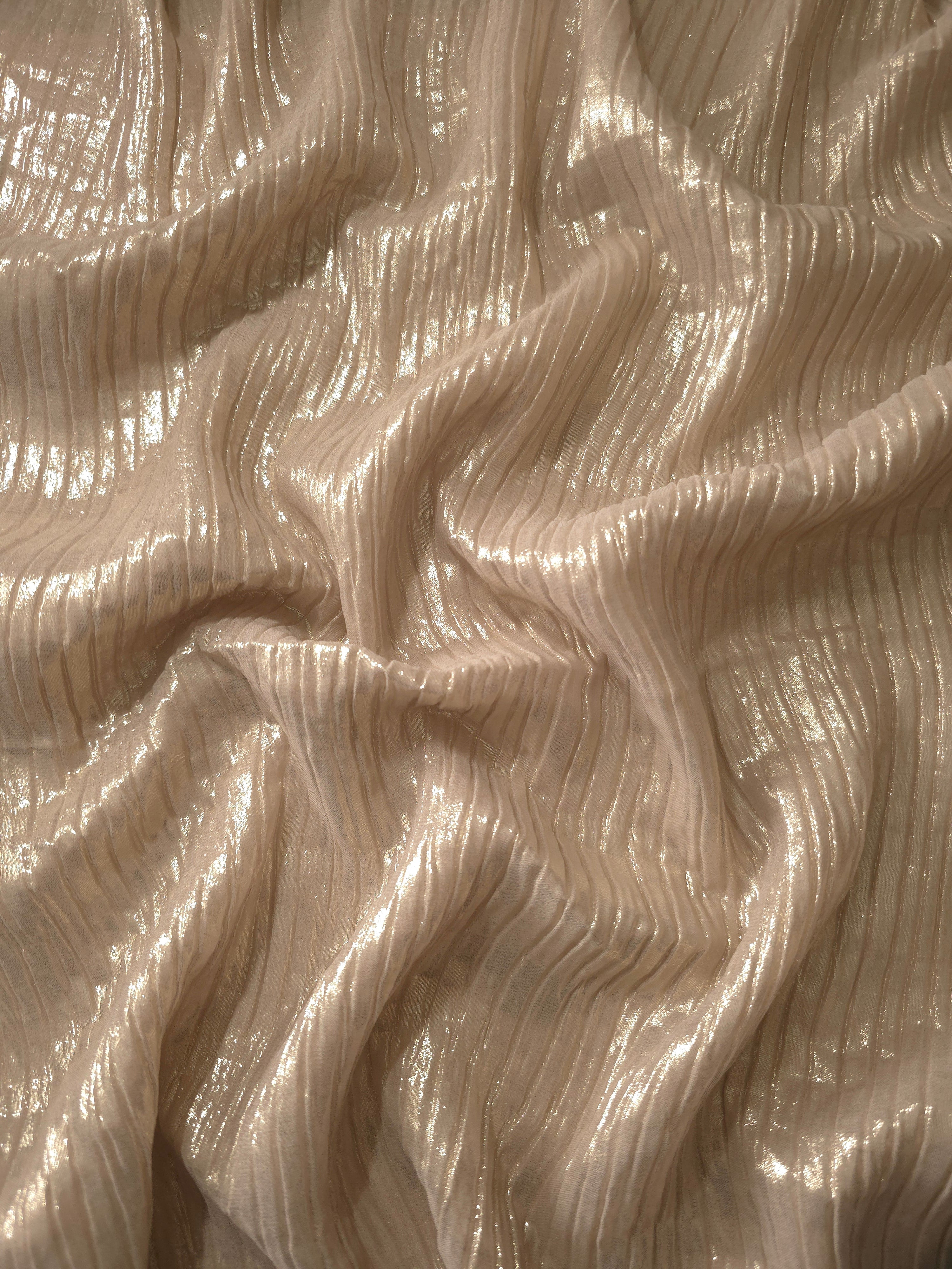 Flowing drape of Light Cream classic plissé shimmer fabric, showing regular pleated texture and light-catching movement for evening gowns and flowing maxi skirts.