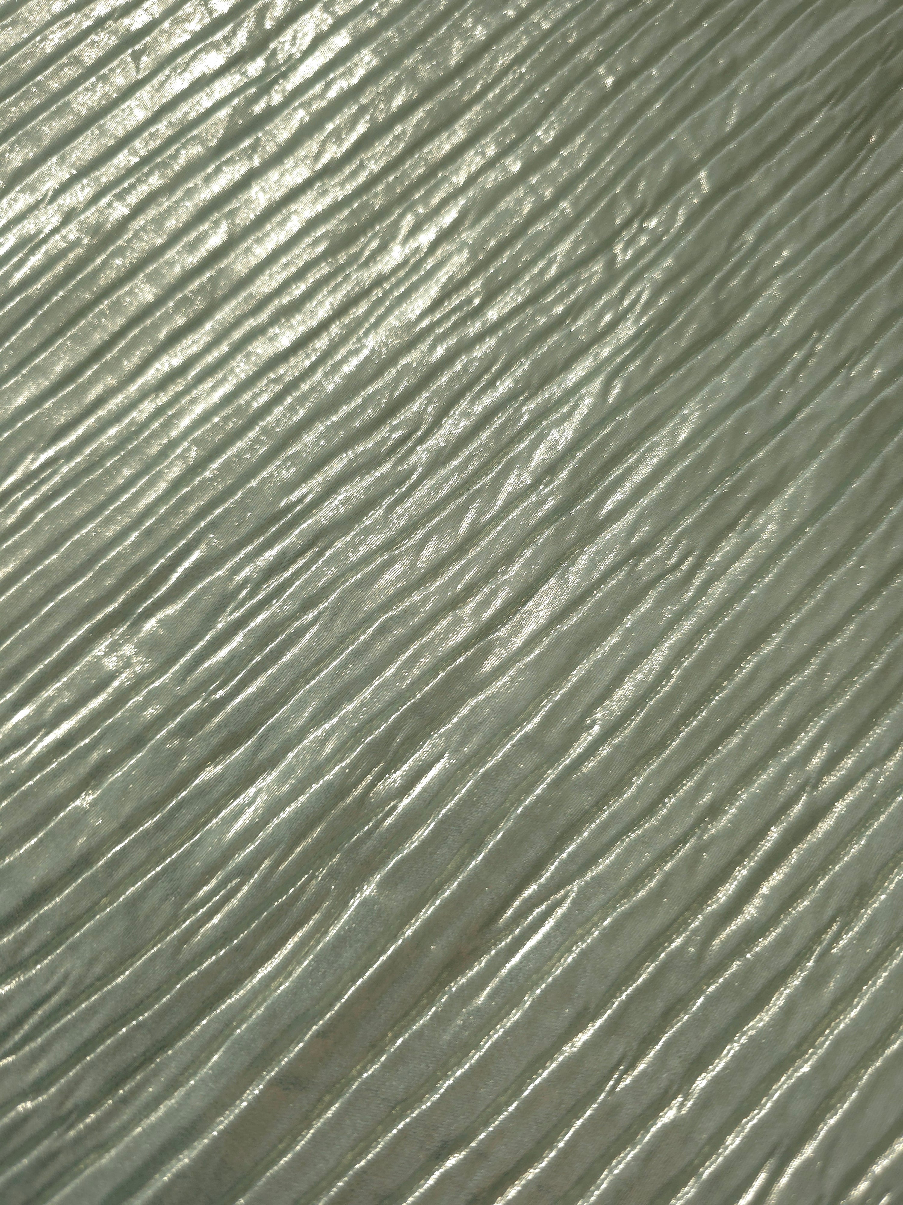 Soft drape of Soft Sage textured shimmer plissé reveals dimensional folds and shifting reflection for jumpsuits and fluid occasionwear.