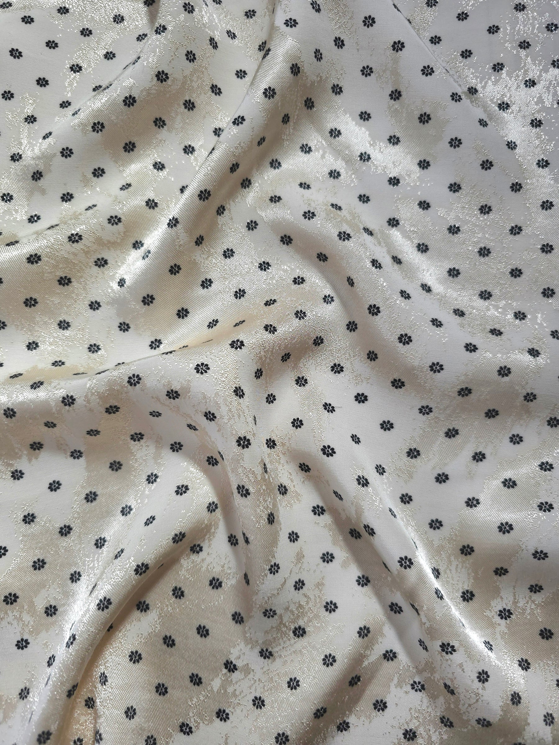 Small Flower printed jacquard fabric in a wave fold, showing print and texture