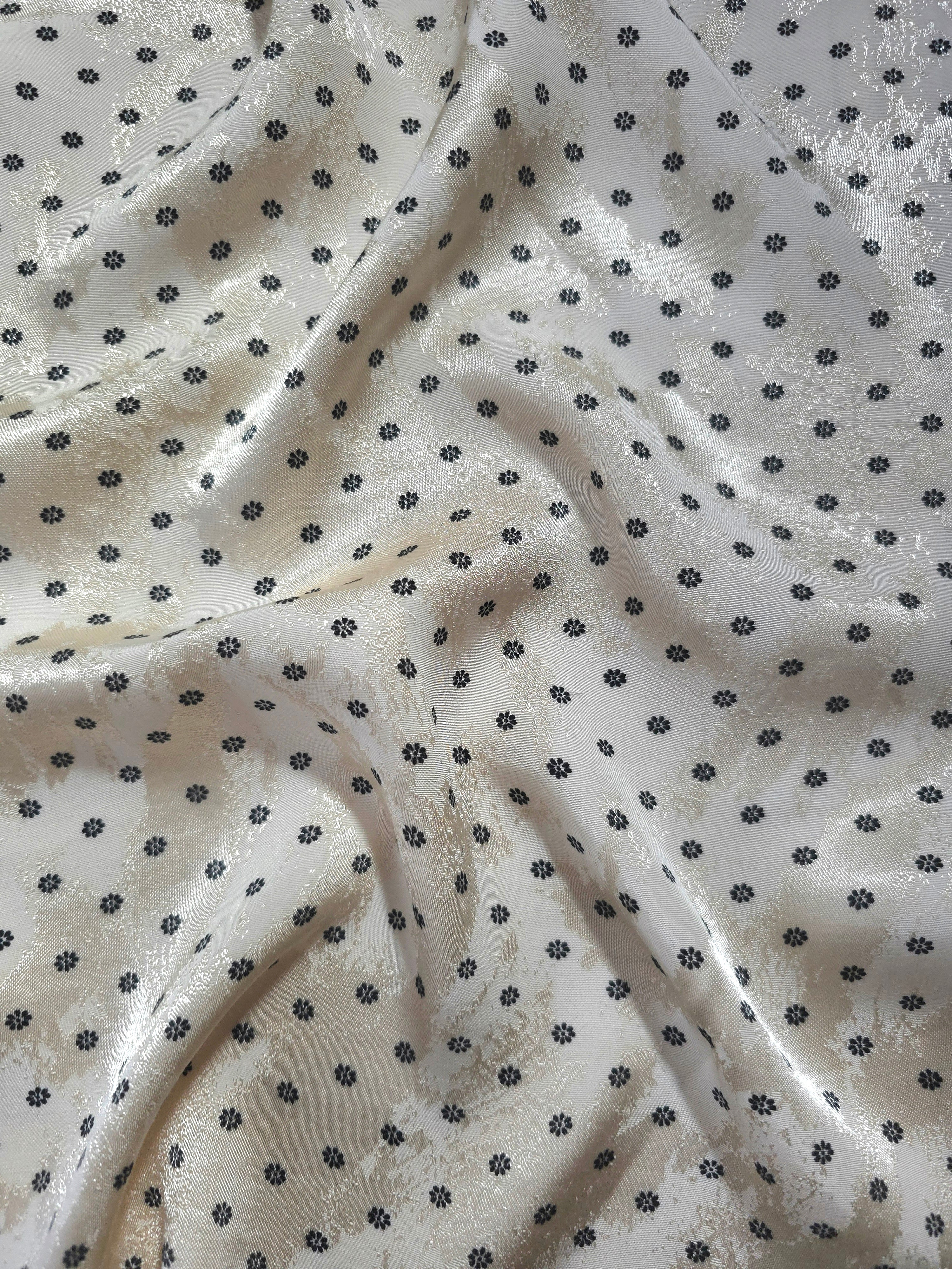 Small Flower printed jacquard fabric in a wave fold, showing print and texture