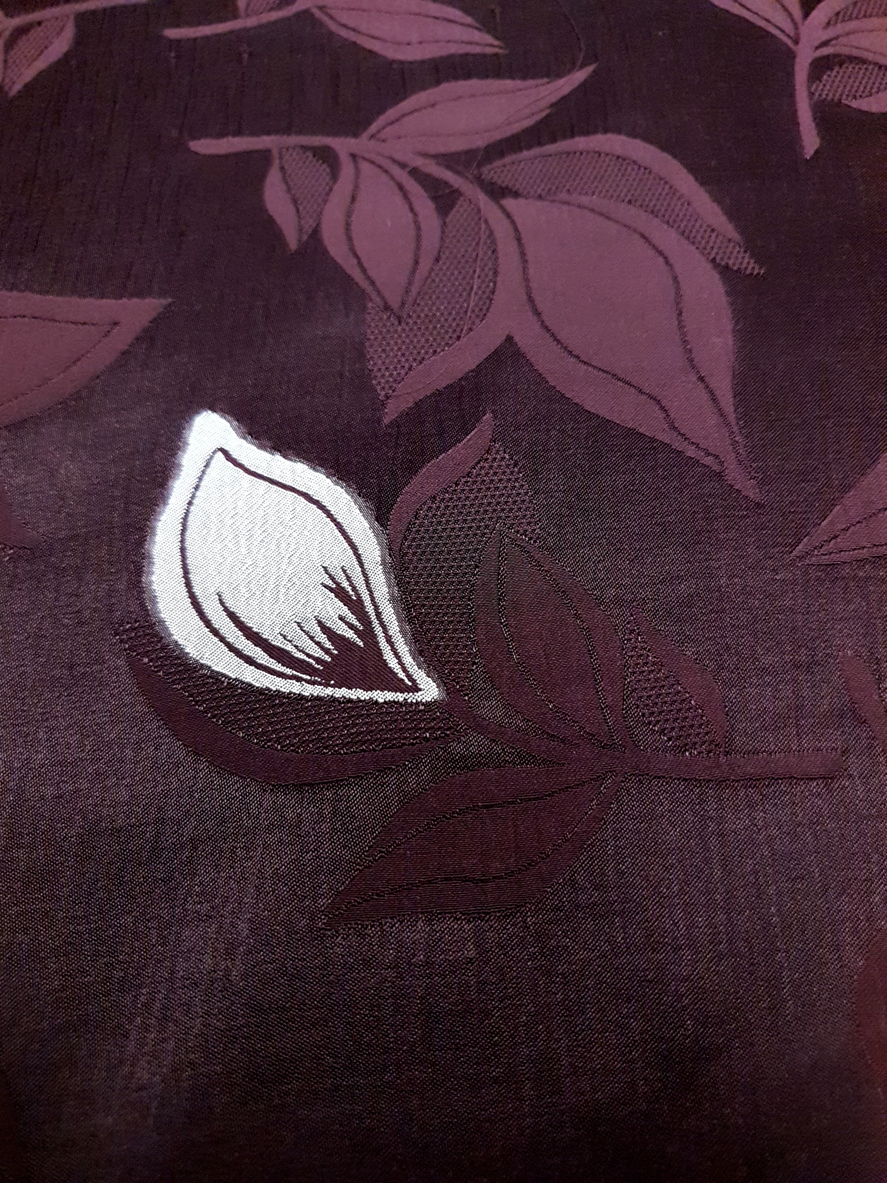 Close texture of two-tone viscose jacquard with embossed woven surface.