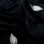 Wave shot of two-tone embossed jacquard fabric with soft drape.