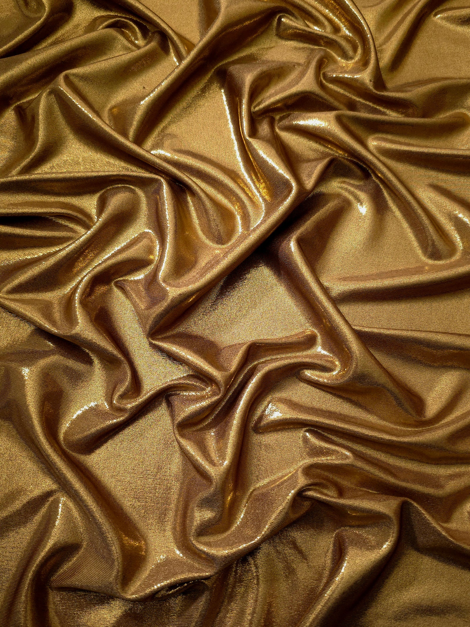 Draped Antique Bronze shimmer spandex fabric with luminous foil reflection, suited to gowns, skirts and theatrical apparel