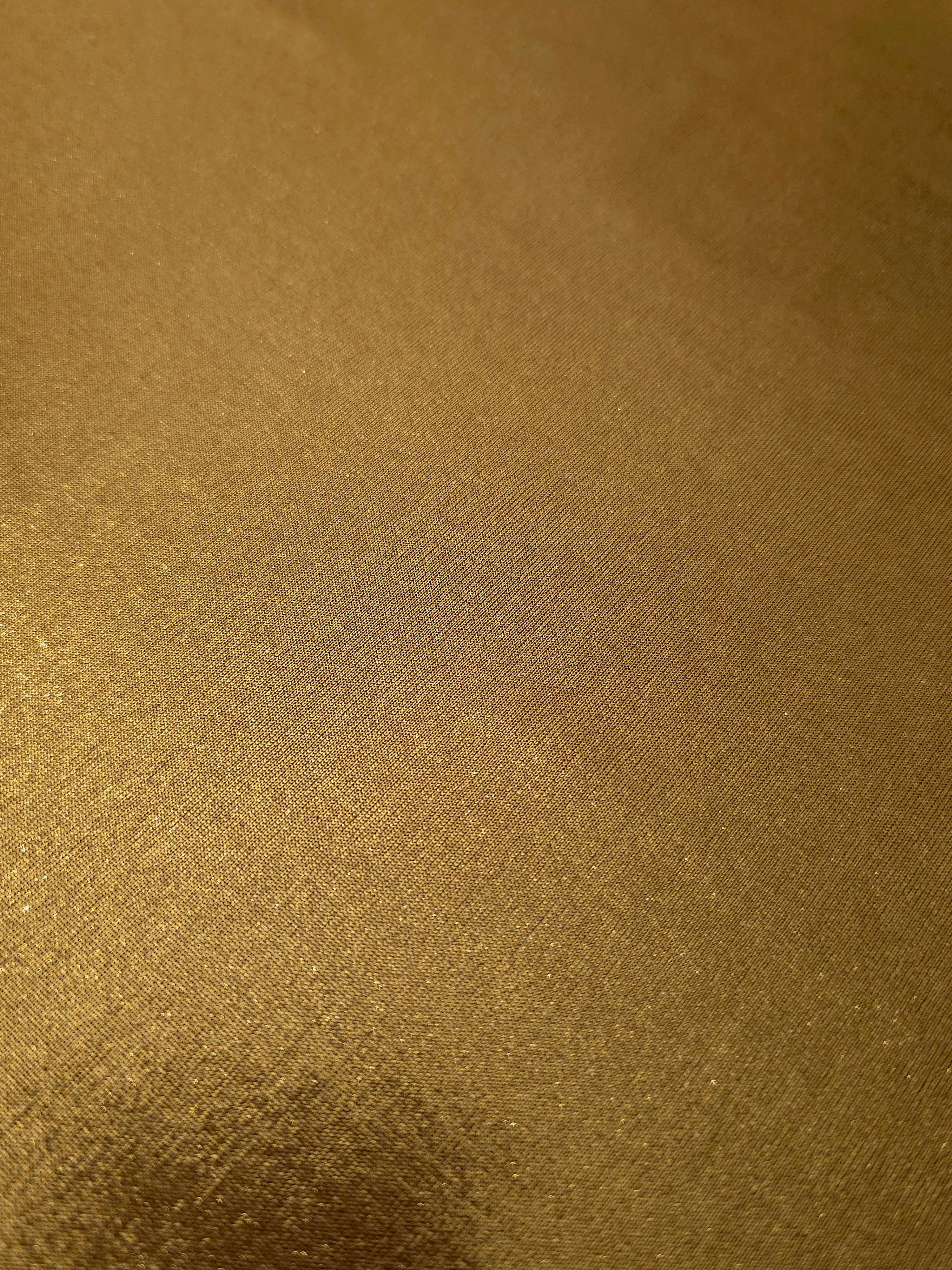 Gently folded Antique Bronze shimmer spandex fabric showing luminous foil finish for tops, skirts and occasion garments