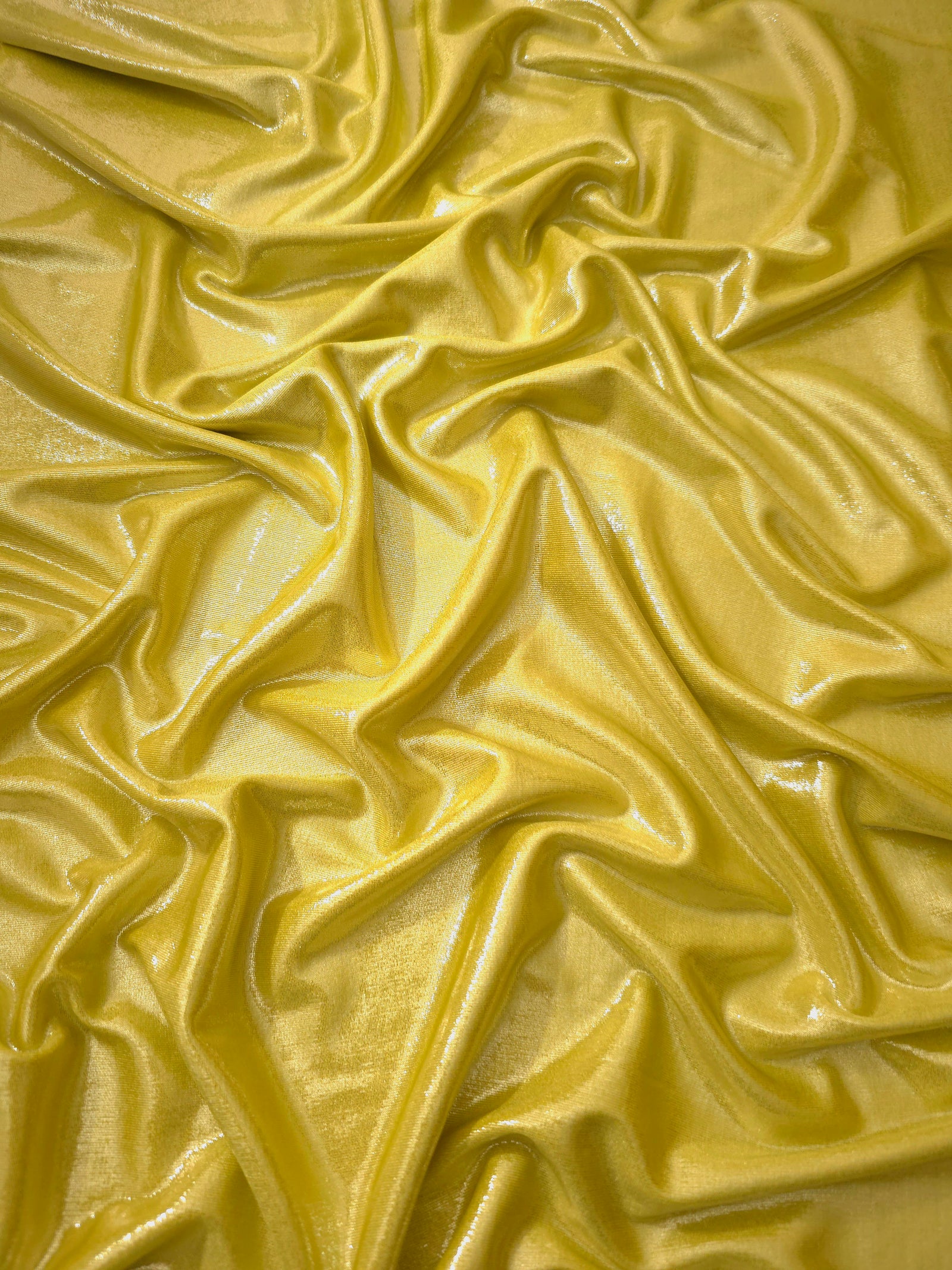 Antique Gold shimmer stretch fabric in draped folds, highlighting metallic foil sheen for evening dresses, costumes and statement apparel