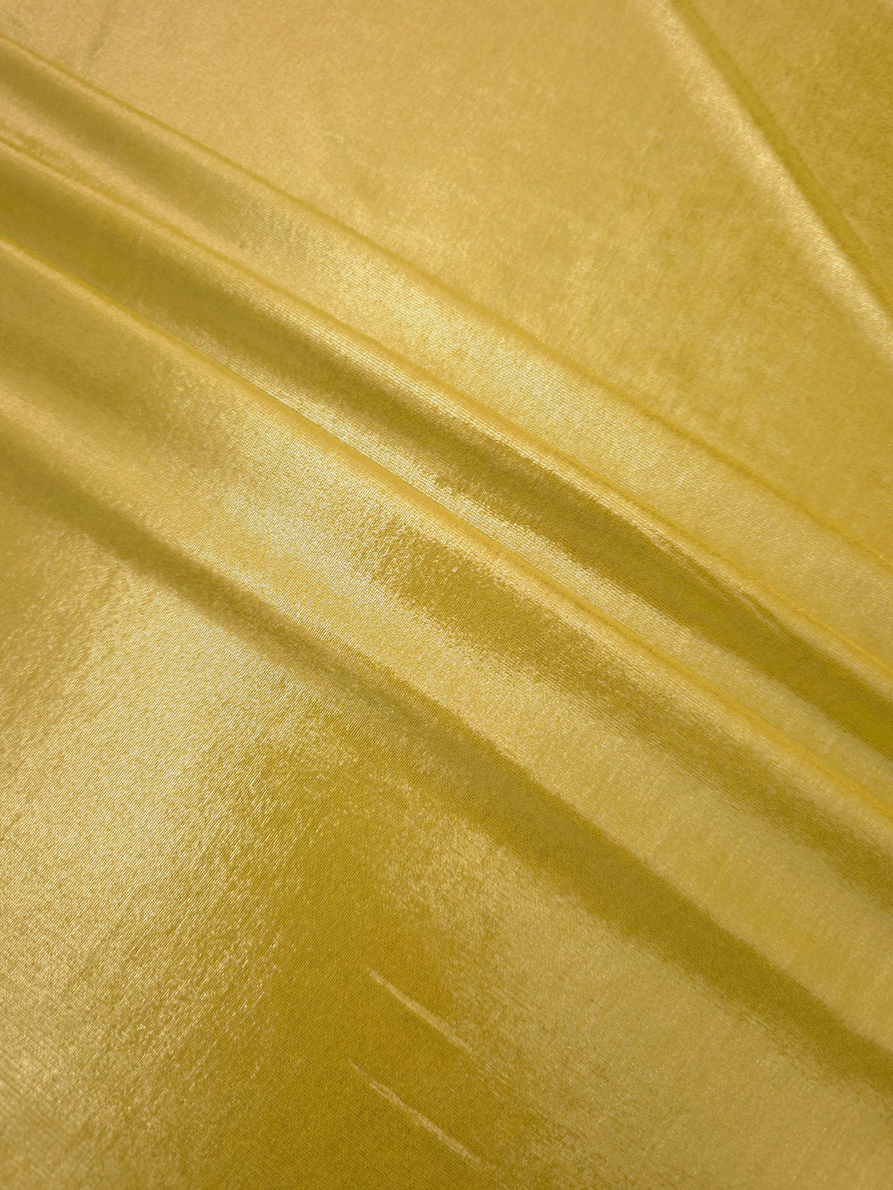 Antique Gold metallic foiled spandex in layered folds, highlighting reflective texture and flexible structure for stage and eveningwear