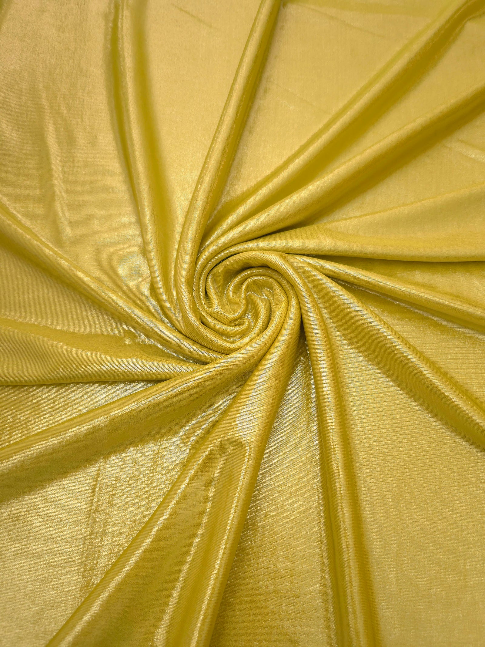 Swirled Antique Gold metallic foiled spandex showing fluid movement and luminous sheen for dresses, dancewear and stage costumes