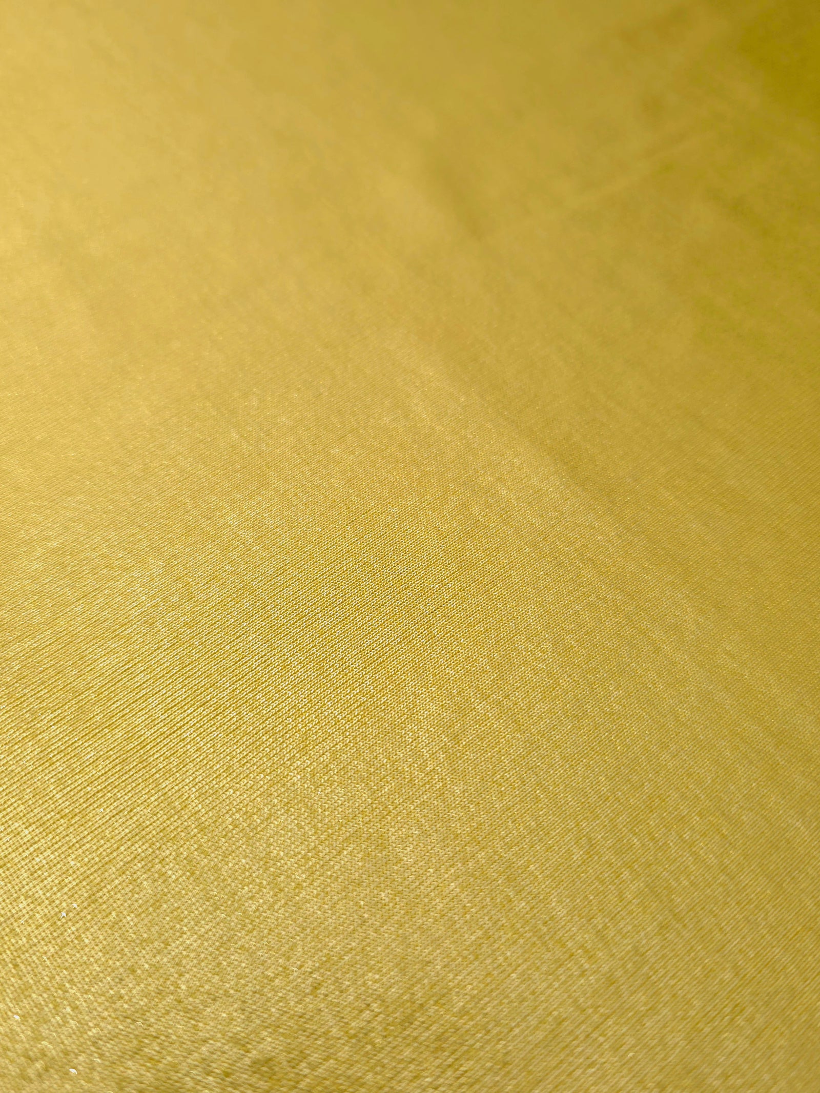 Antique Gold shimmer stretch fabric close-up, revealing metallic foil texture and reflective detail for fashion and costume sewing