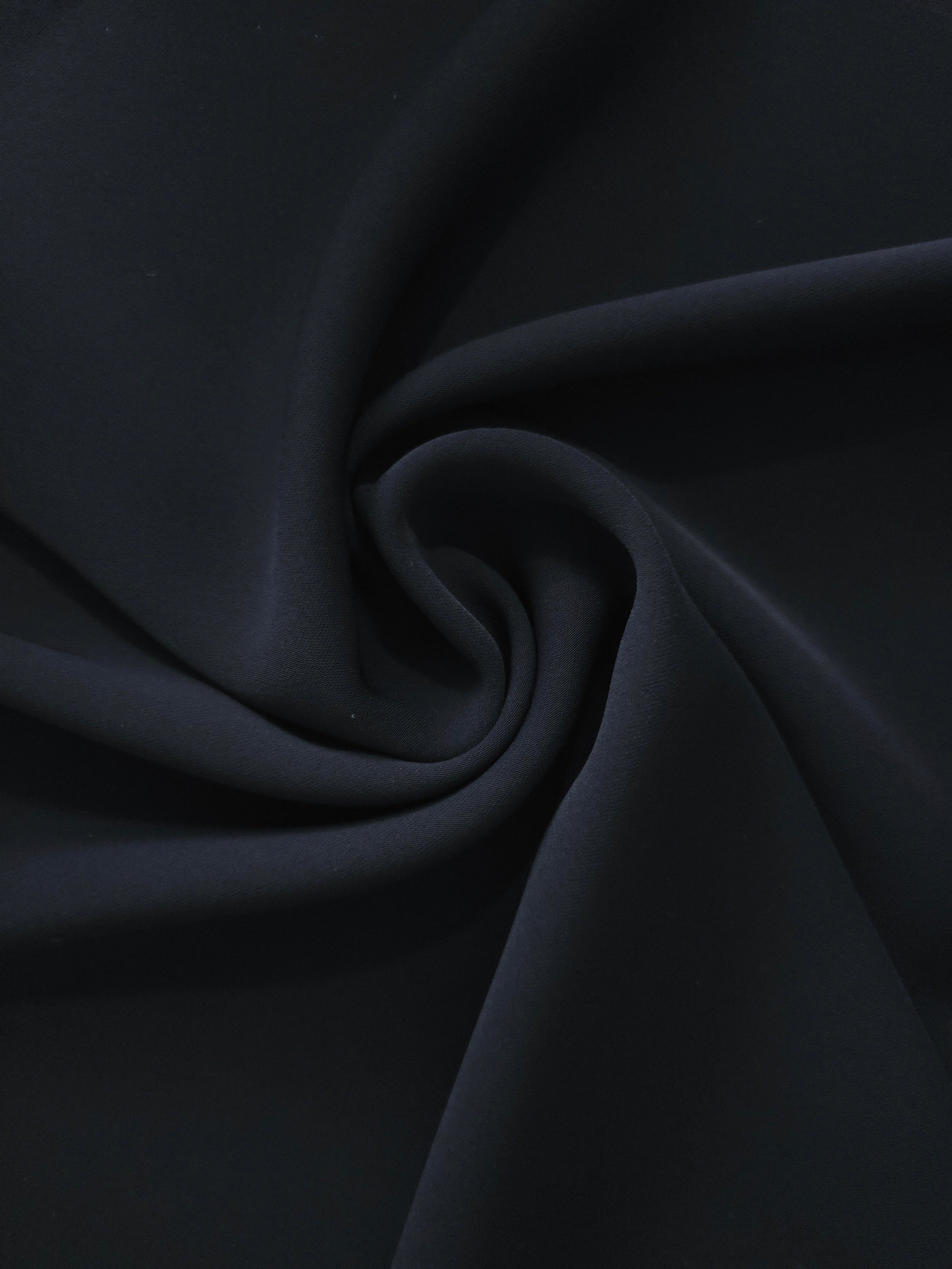 Spiral styling of Blue Black polyester crepe showing supple drape for abayas, dresses and occasionwear