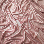 Blush Champagne shimmer stretch fabric in draped folds, highlighting metallic foil sheen for evening dresses, costumes and statement apparel