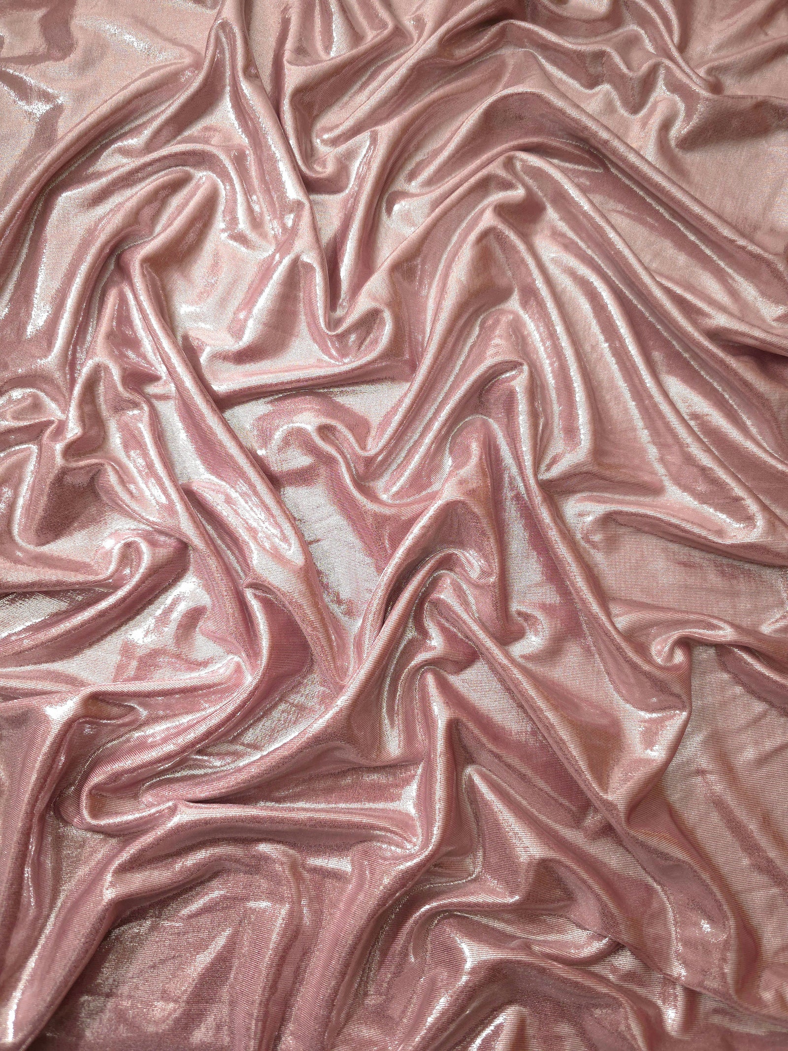 Blush Champagne shimmer stretch fabric in draped folds, highlighting metallic foil sheen for evening dresses, costumes and statement apparel