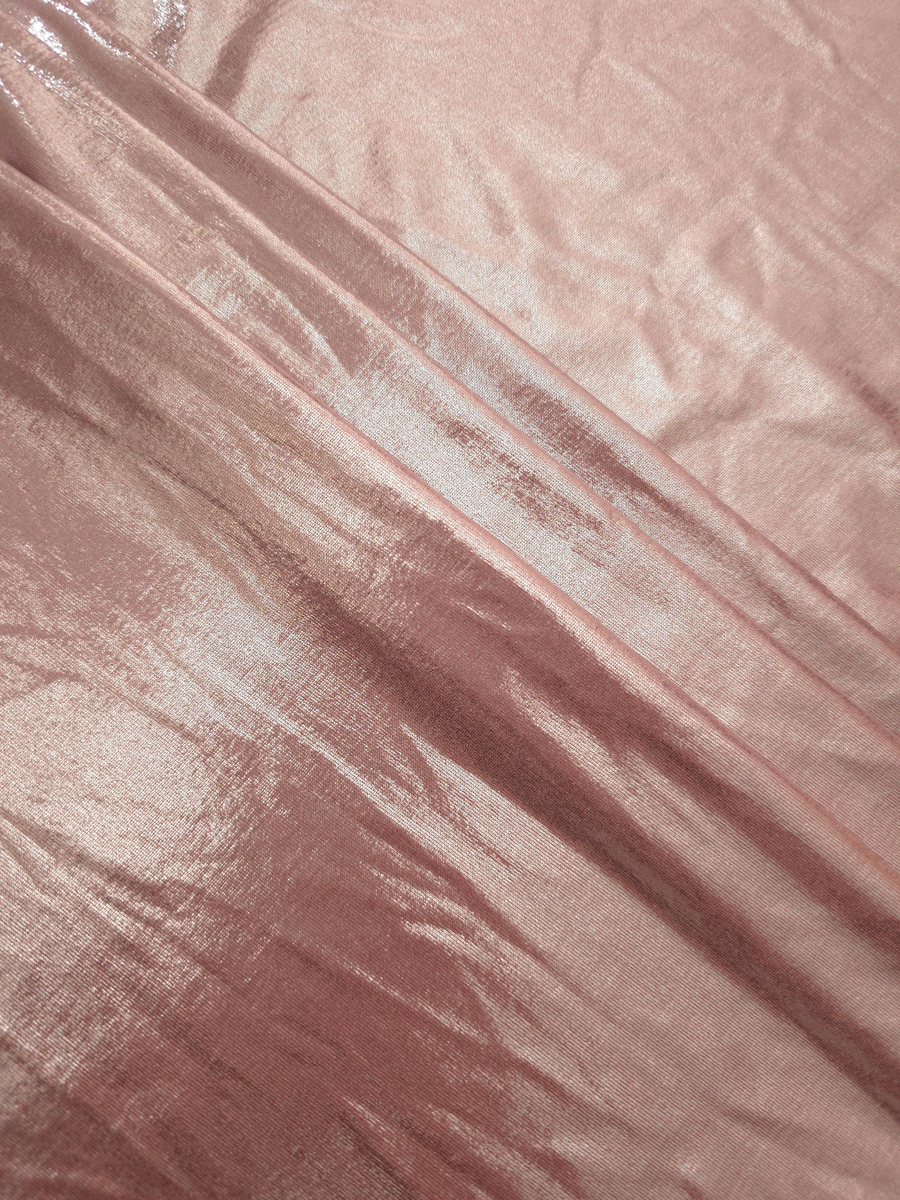 Blush Champagne metallic foiled spandex in layered folds, highlighting reflective texture and flexible structure for stage and eveningwear