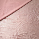 Soft fold of Blush Champagne metallic foiled spandex highlighting reflective sheen and supple movement for dresses and stagewear