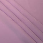 Layered folds of Blush Mauve 100% mechanical polyester crepe showing body and gentle construction stretch