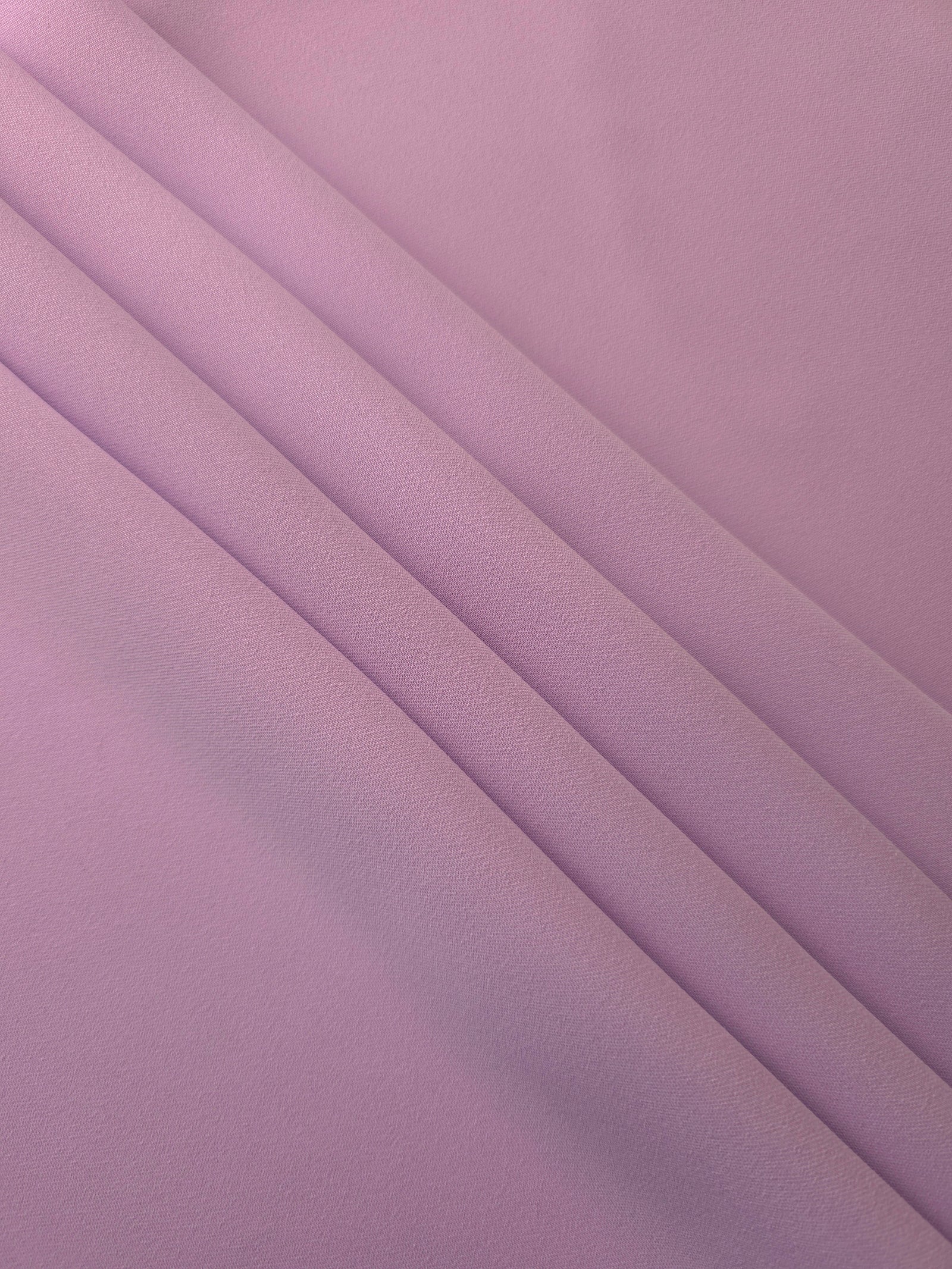 Layered folds of Blush Mauve 100% mechanical polyester crepe showing body and gentle construction stretch