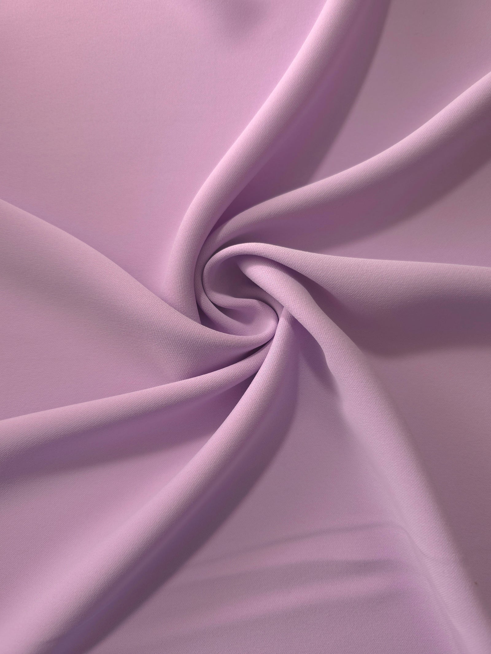 Blush Mauve opaque polyester crepe in a spiral drape, showing flowing form for skirts and modest garments