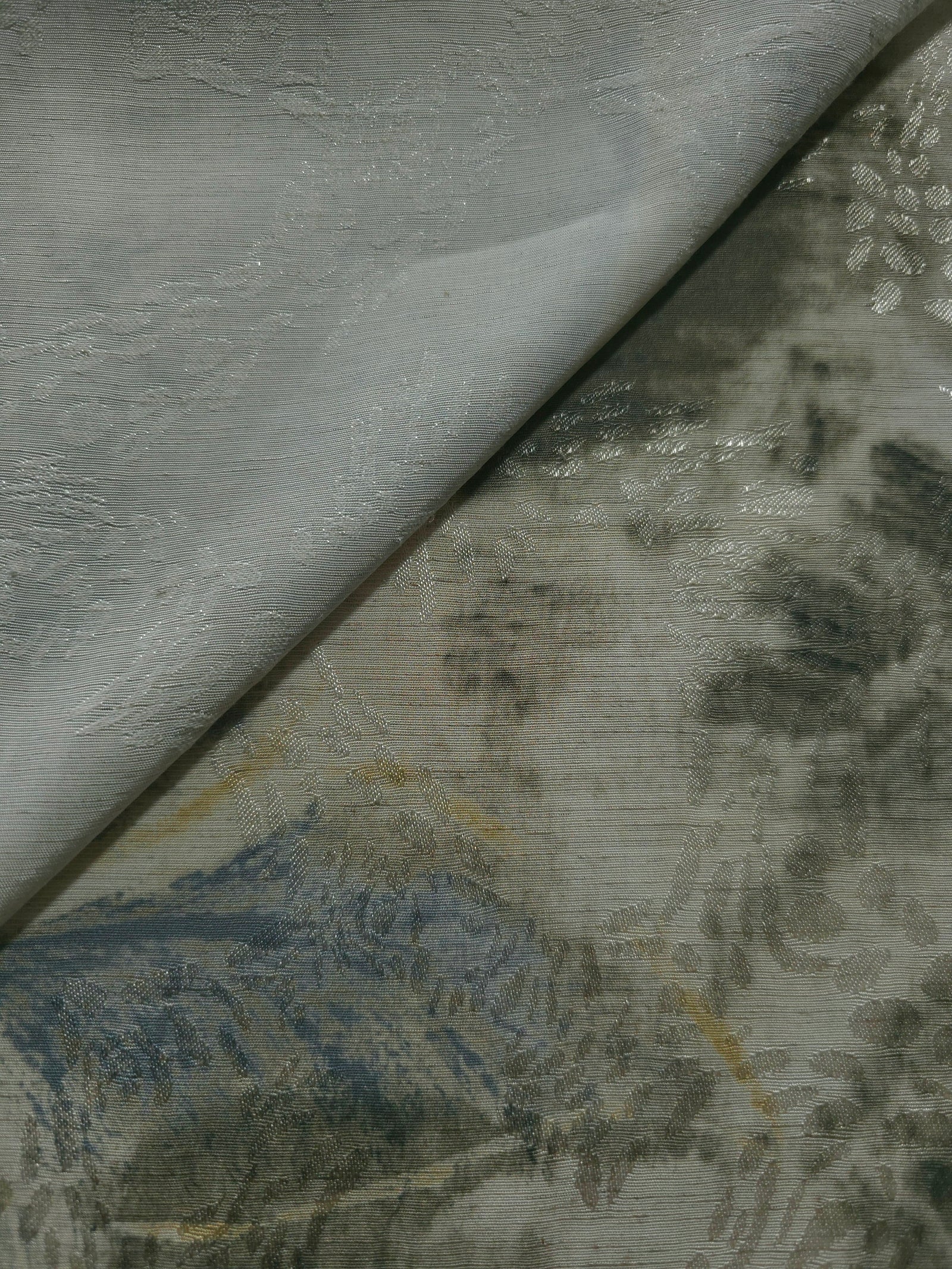 Blue botanical shadow linen-look jacquard fabric close-up with raised woven texture and tonal leaf pattern.